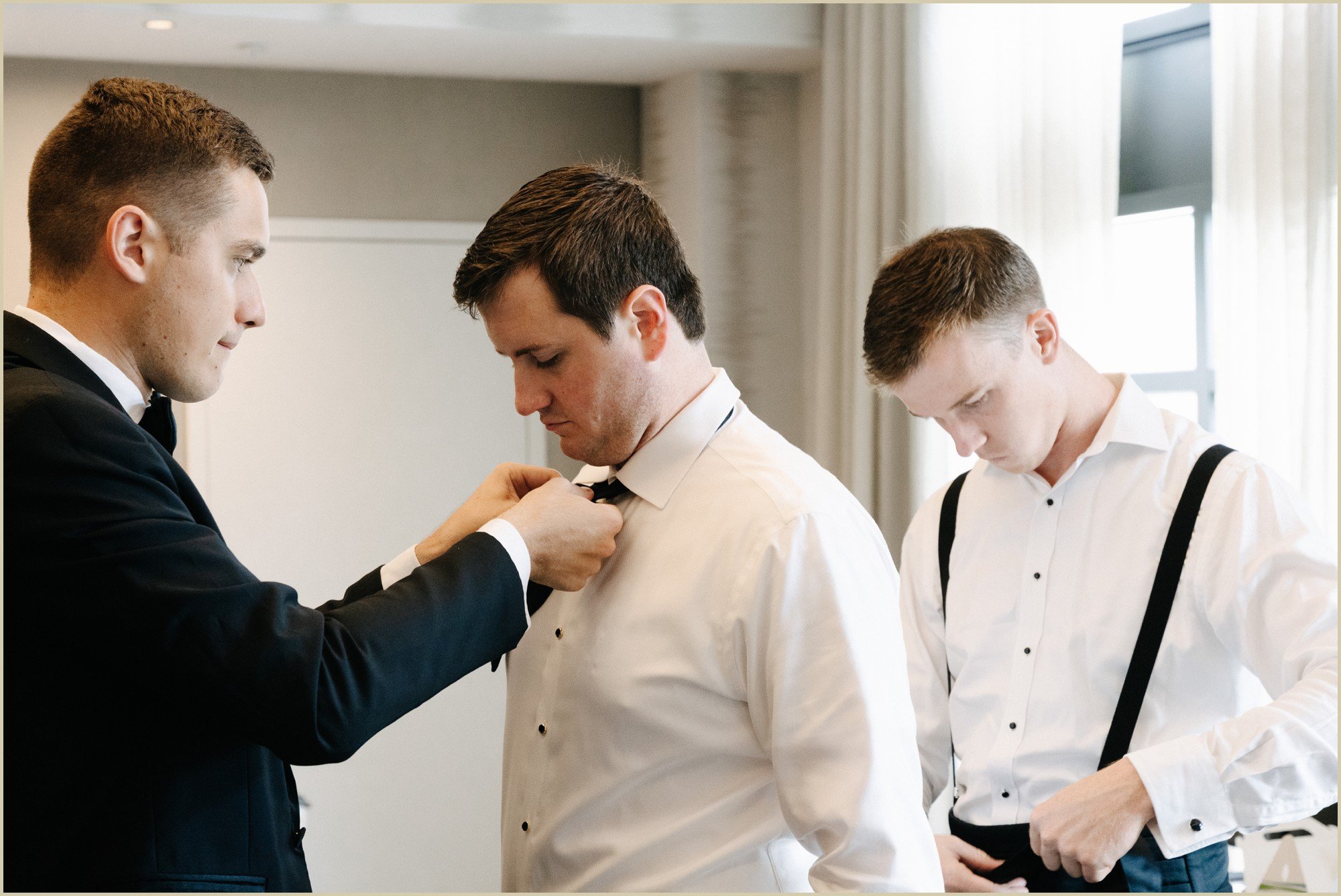 groomsmen adjusting grooms bowtie