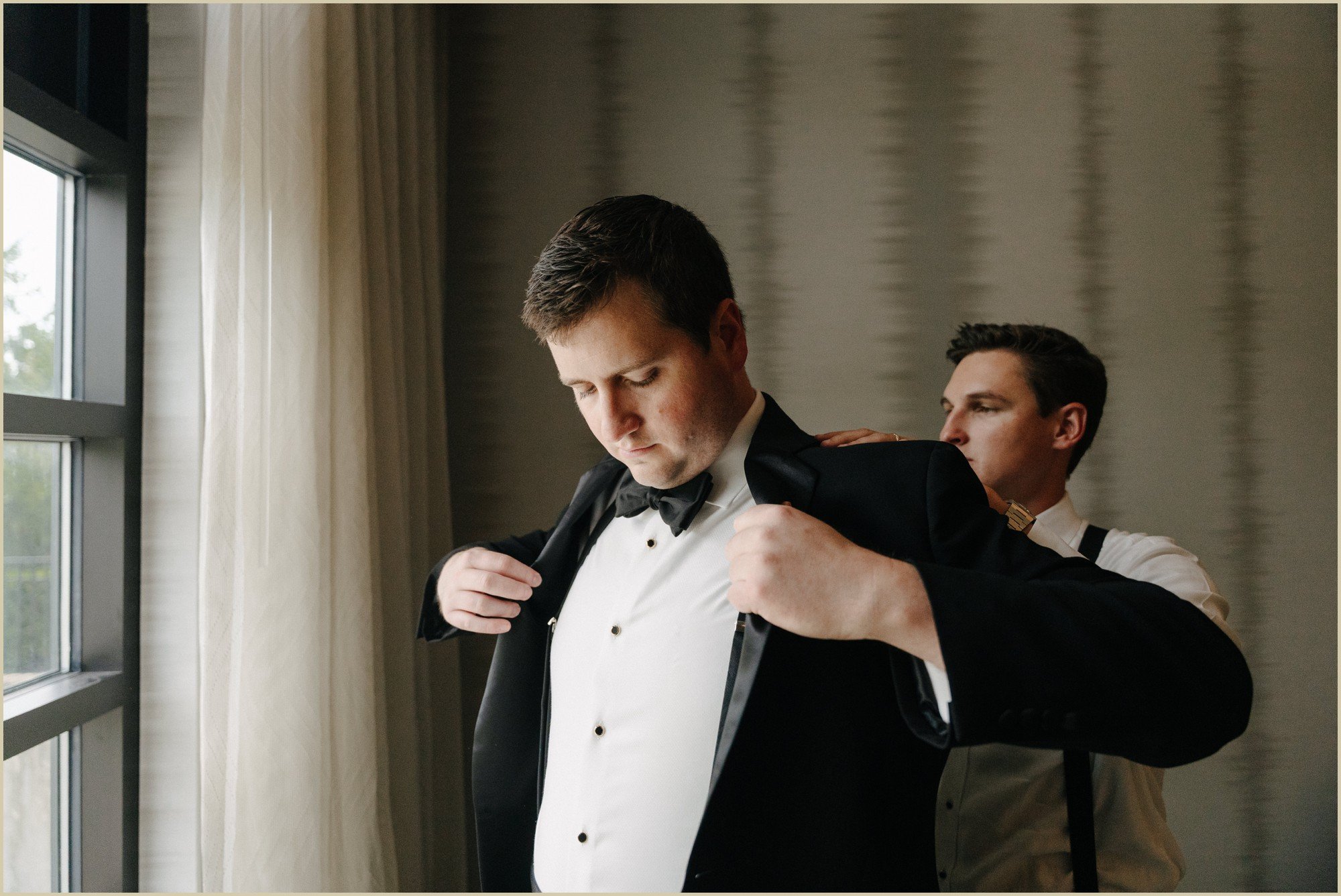 groom putting jacket on