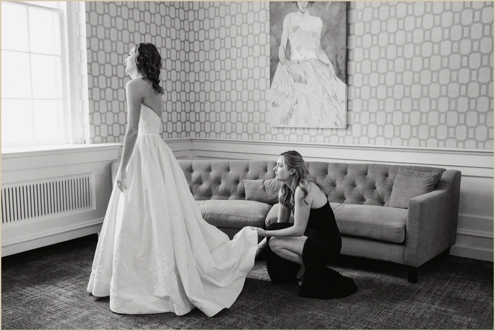 bridesmaid helping with wedding dress