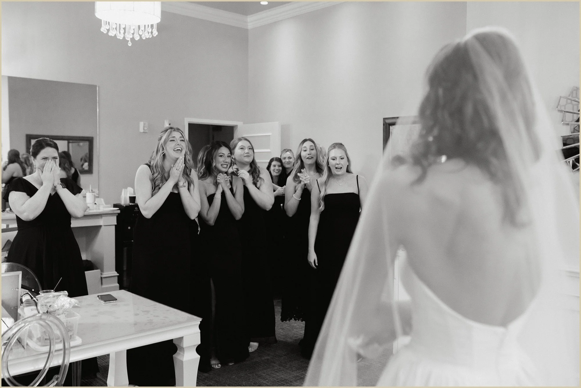 candid photo of bridesmaids seeing bride in dress for the first time