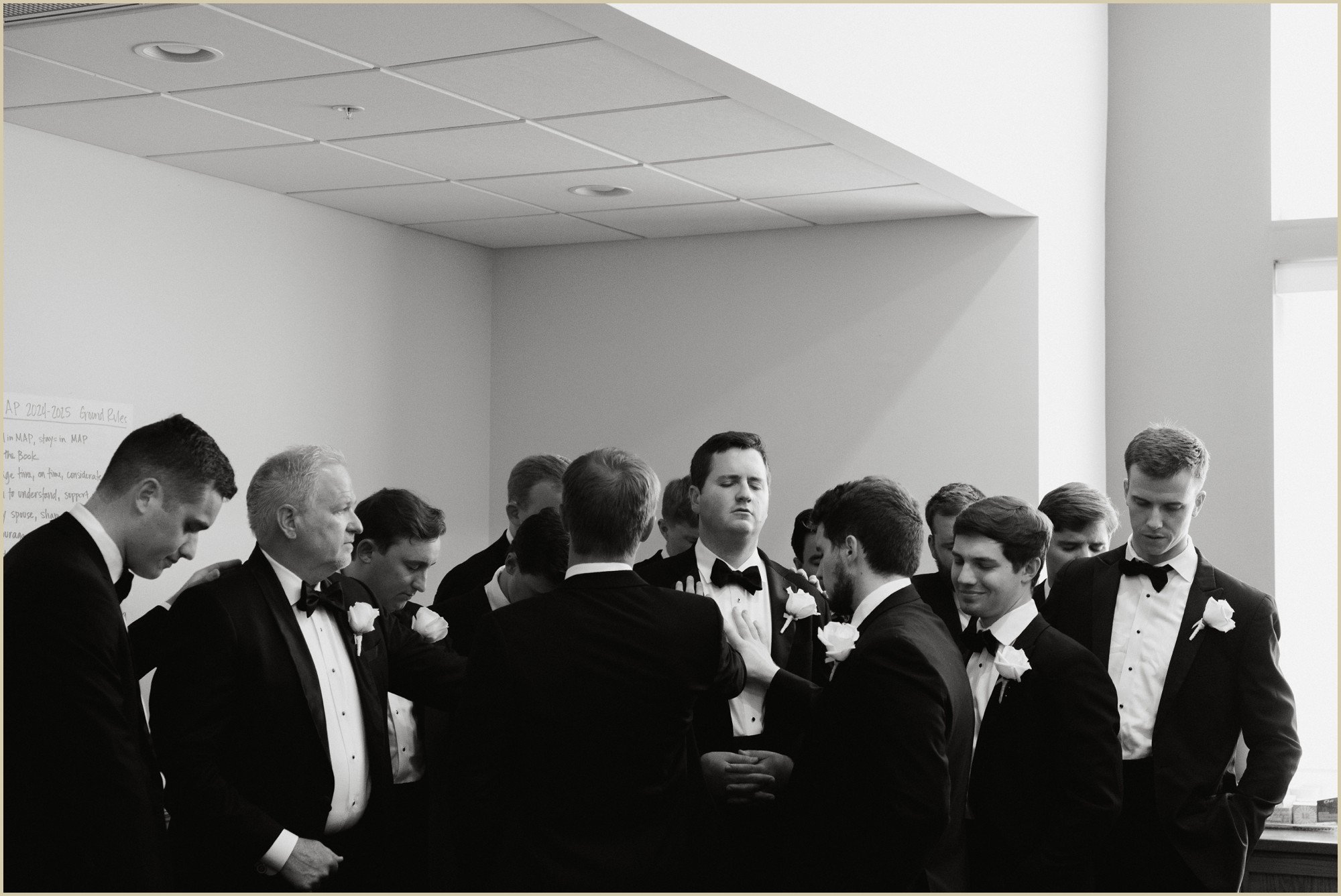groom and groomsmen praying before wedding ceremony