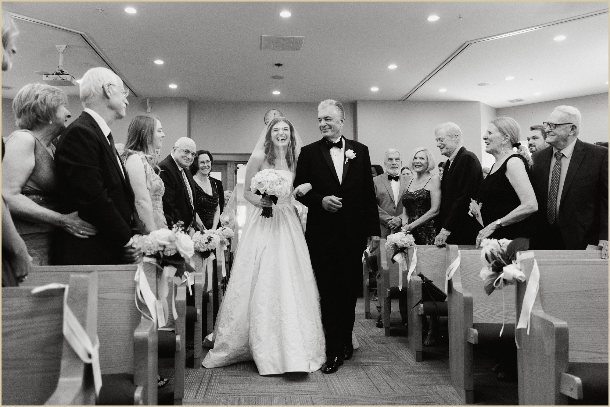 father looking at bride as he walks her down the aisle during wedding ceremony