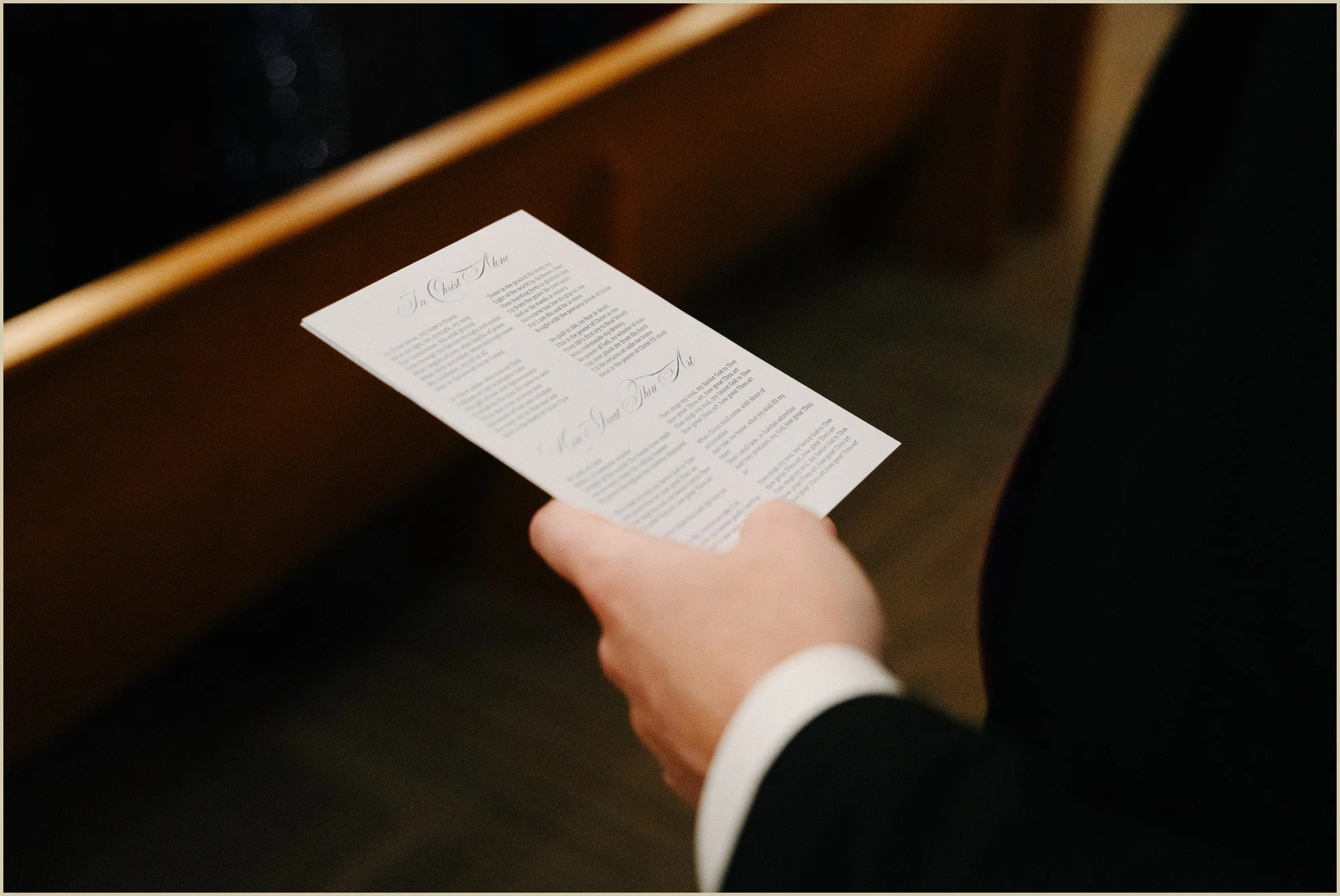 detail of guest holding a wedding ceremony program