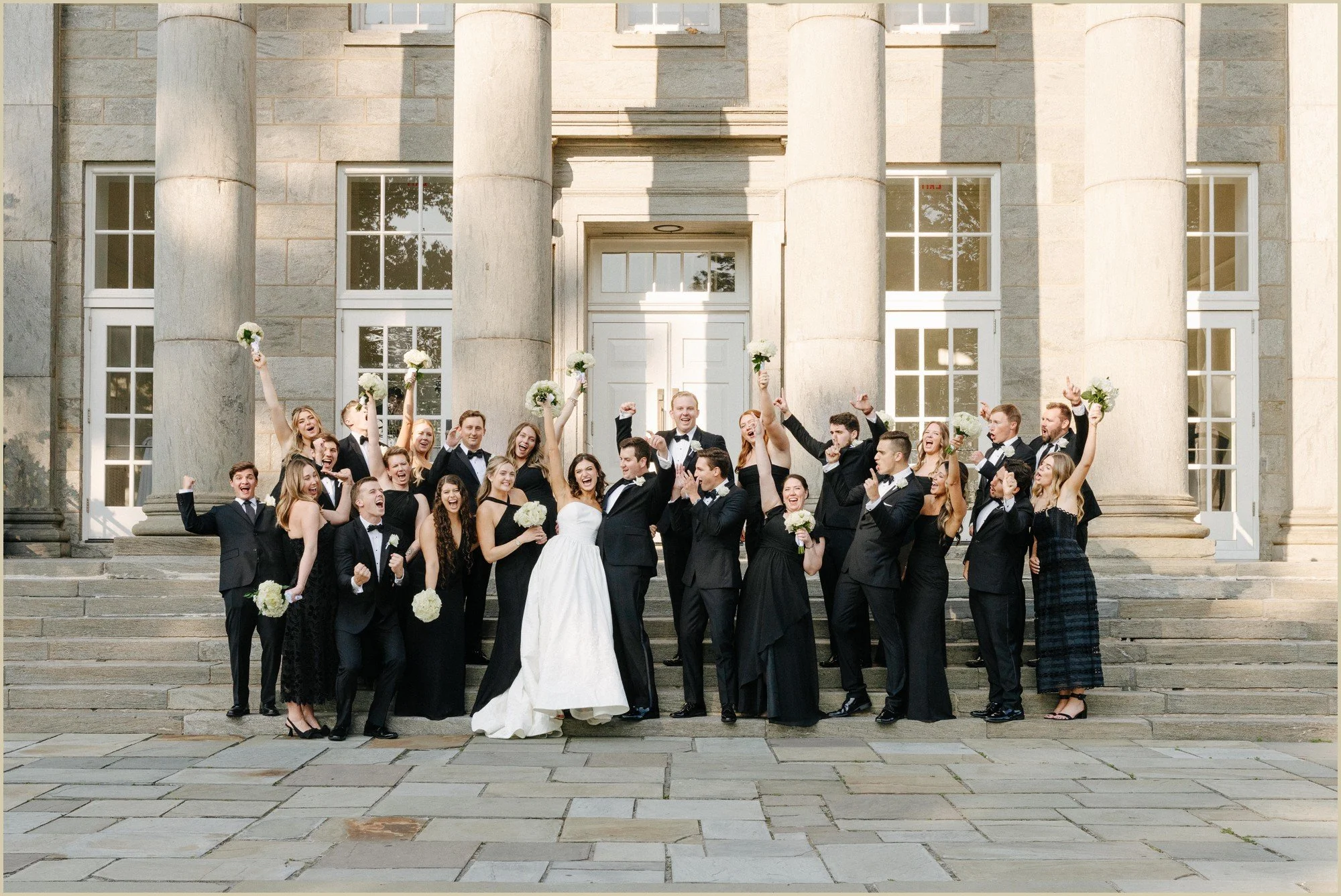 large wedding party portrait cheering on the front step of the ballroom at ellis preserve