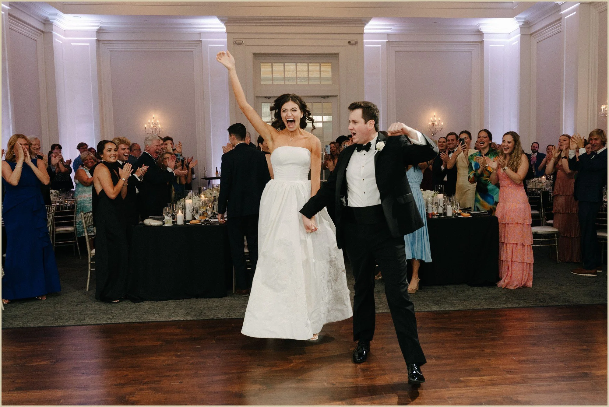 bride and groom jumping up and laughing excitedly as they are introduced into their reception
