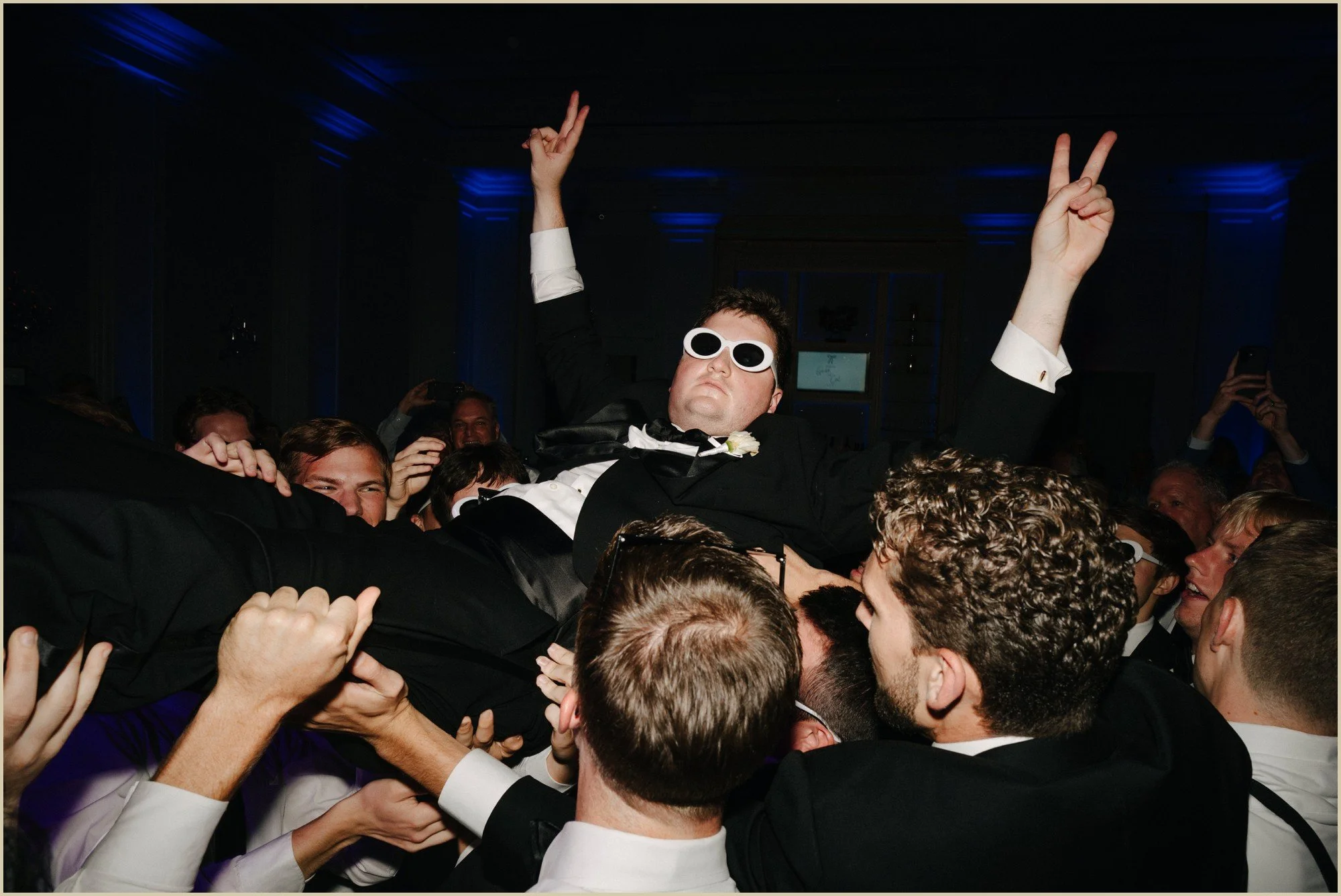 groom crowd surfing with sunglasses on
