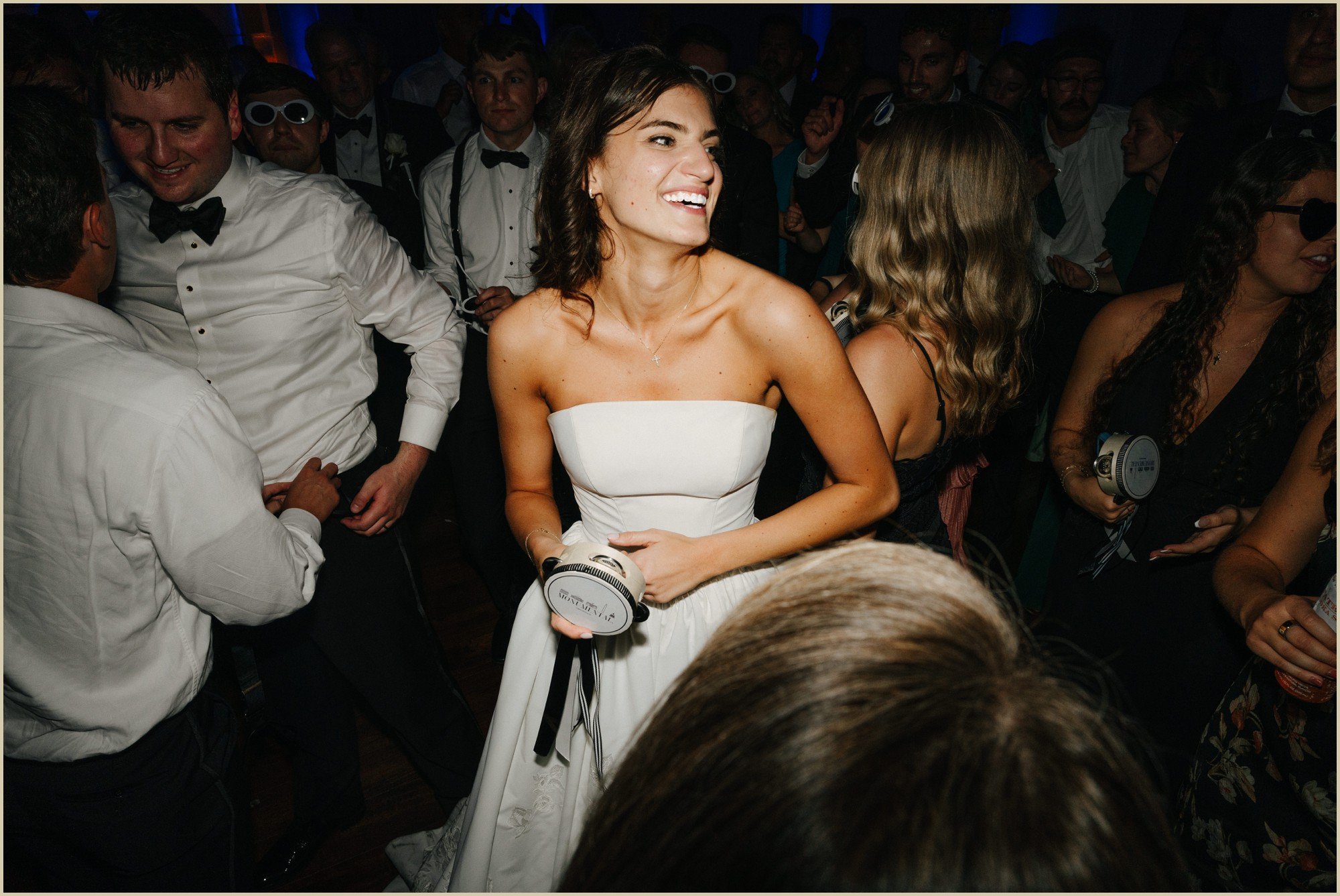 bride on the dance floor laughing and holding a mini tambourine