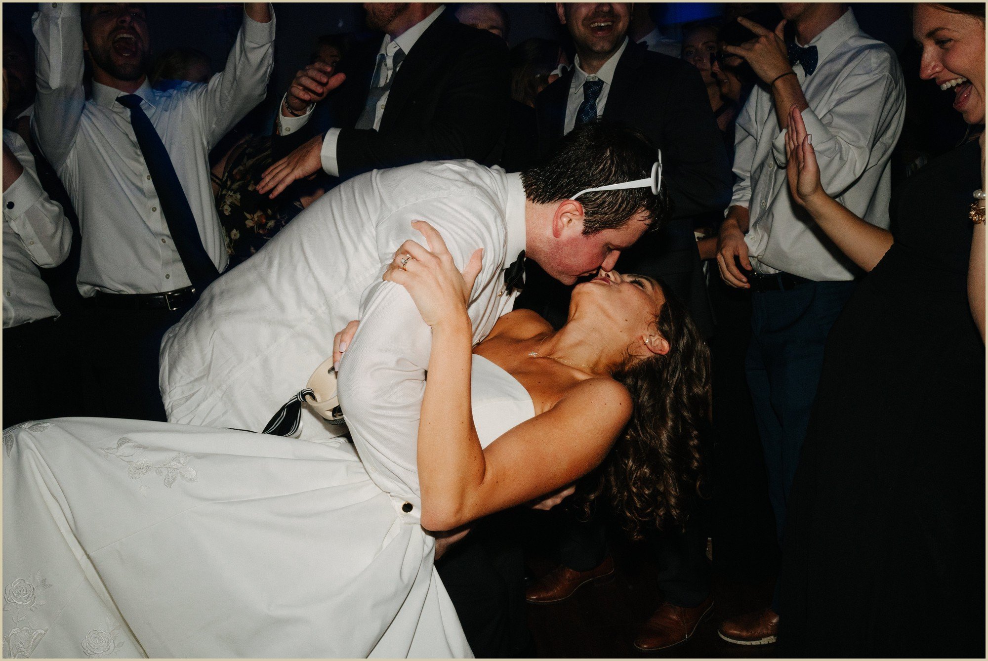 groom dips bride during the party on the dance floor