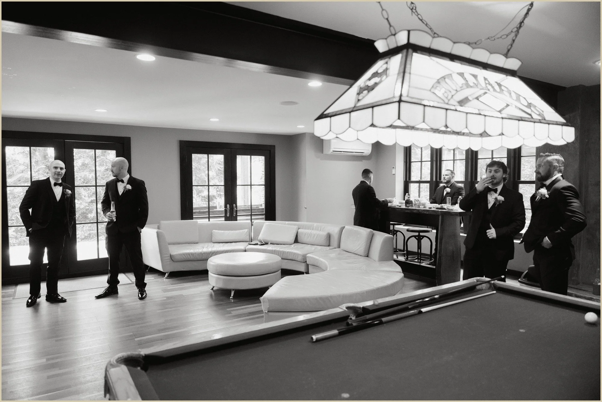 documentary wedding photo of groom hanging out with friends at the lake house inn