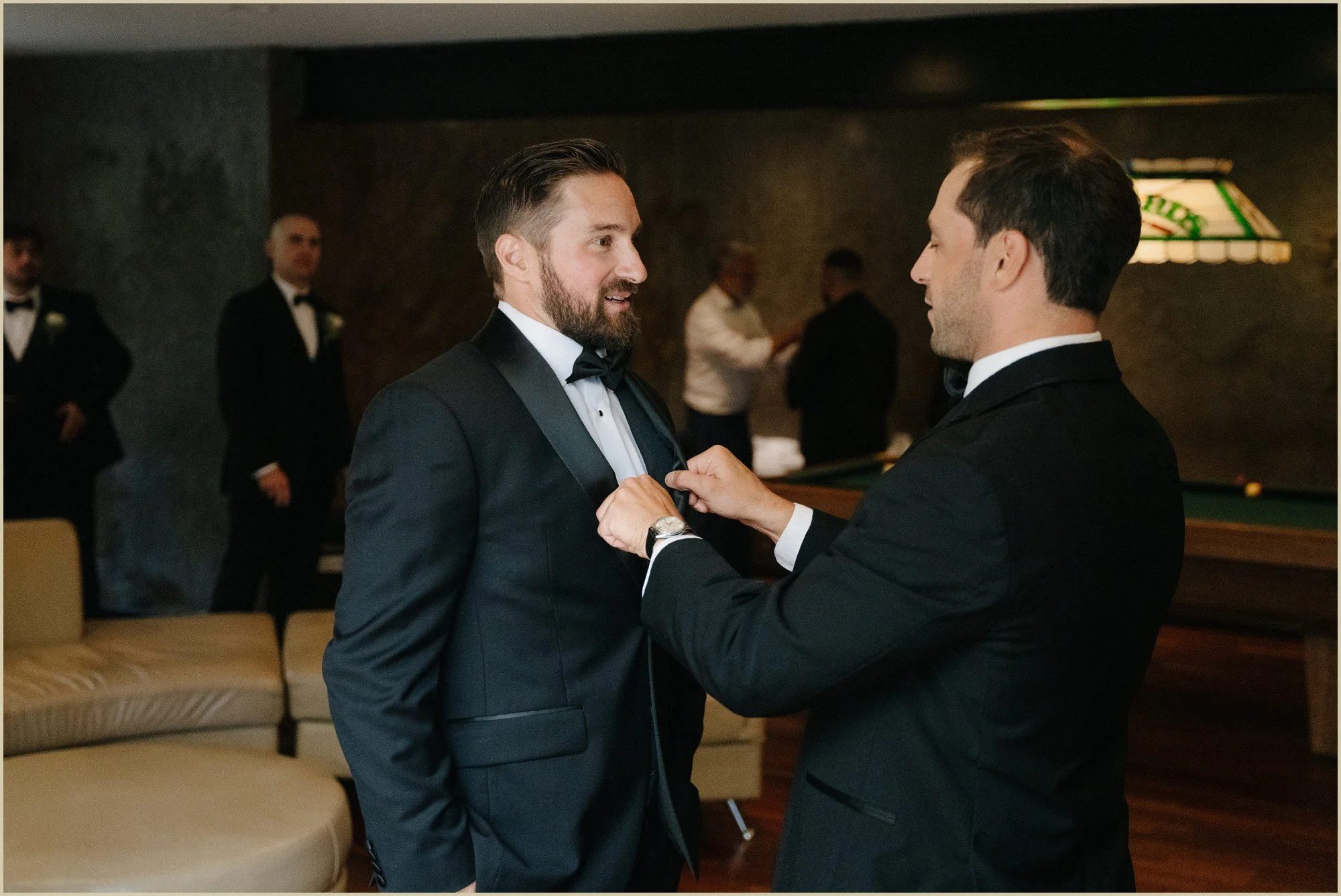 groomsmen helping groom with tie