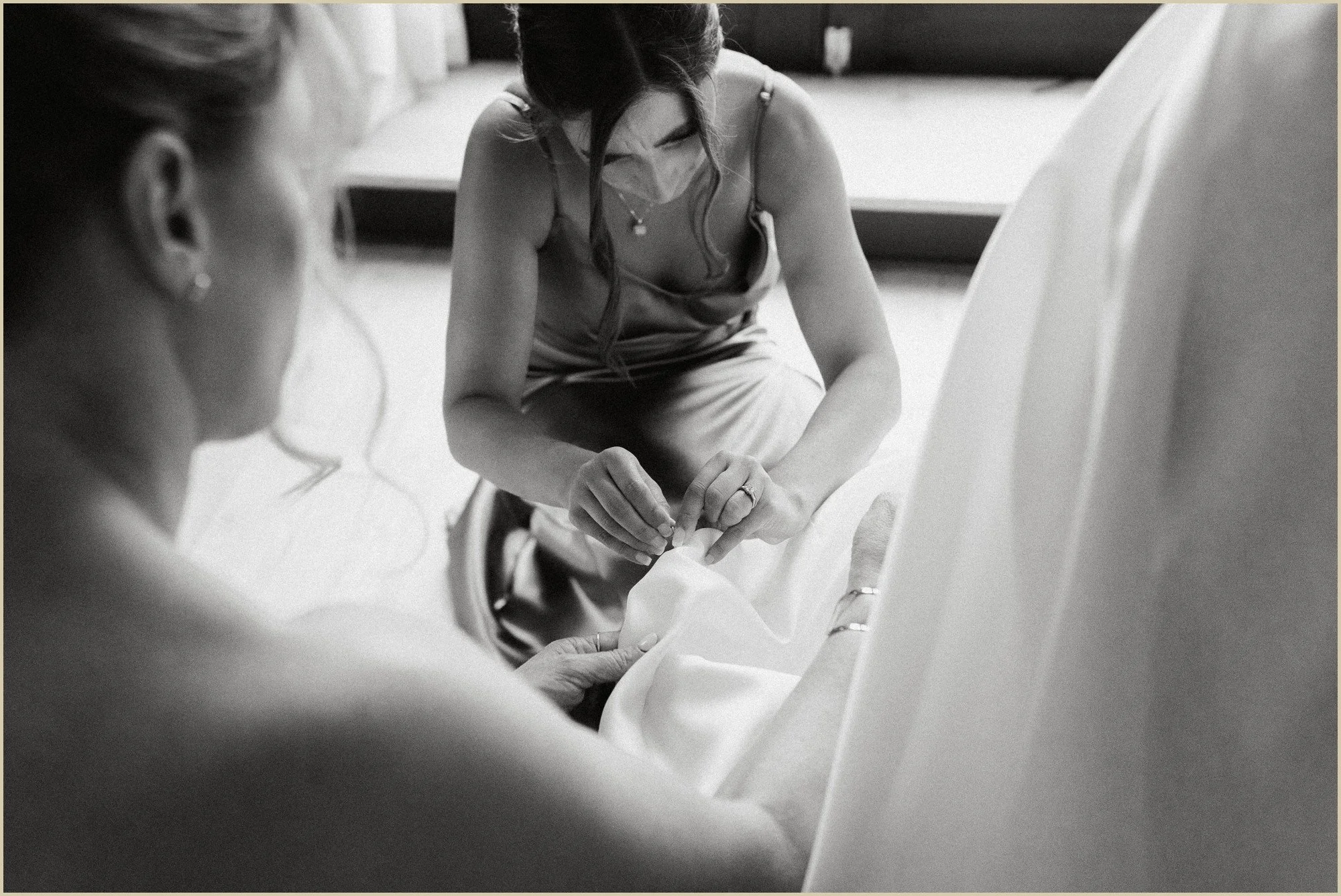 bridesmaids helping bride with train on dress