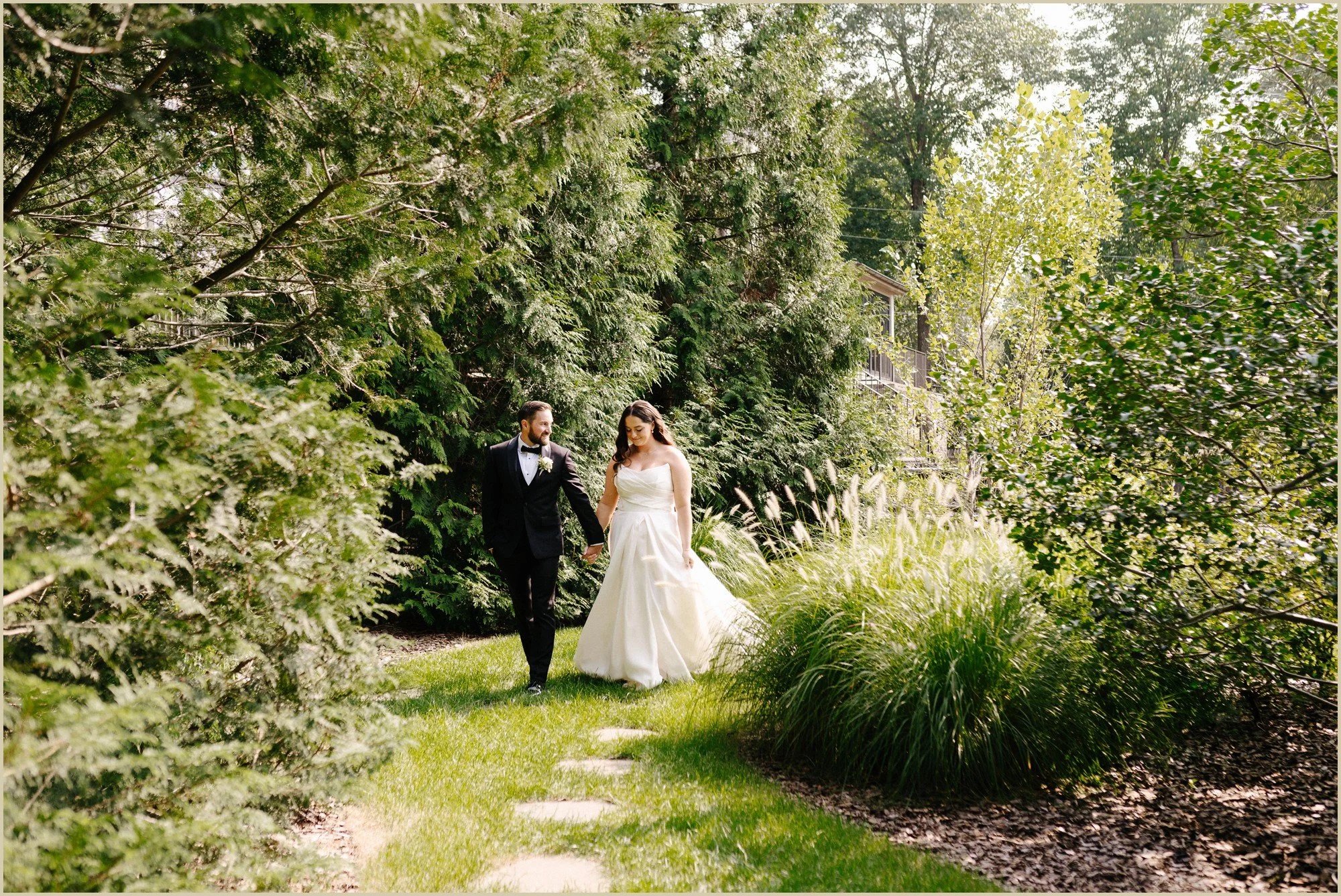 bride and groom walking down a path talking