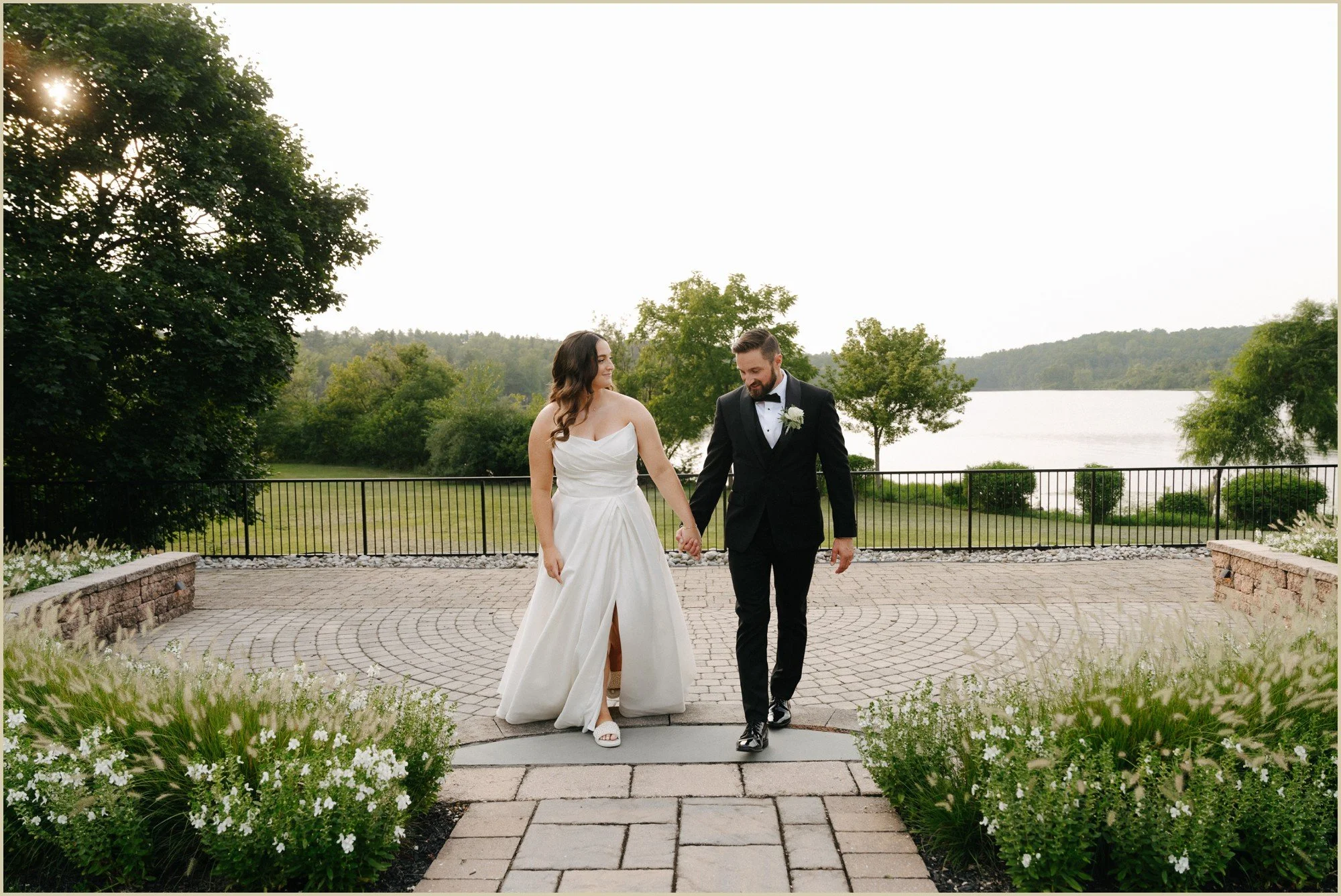 bride and groom walking with beautiful lake in the background