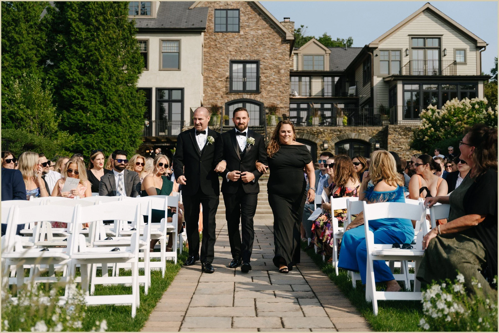 groom walking down the aisle with his parents