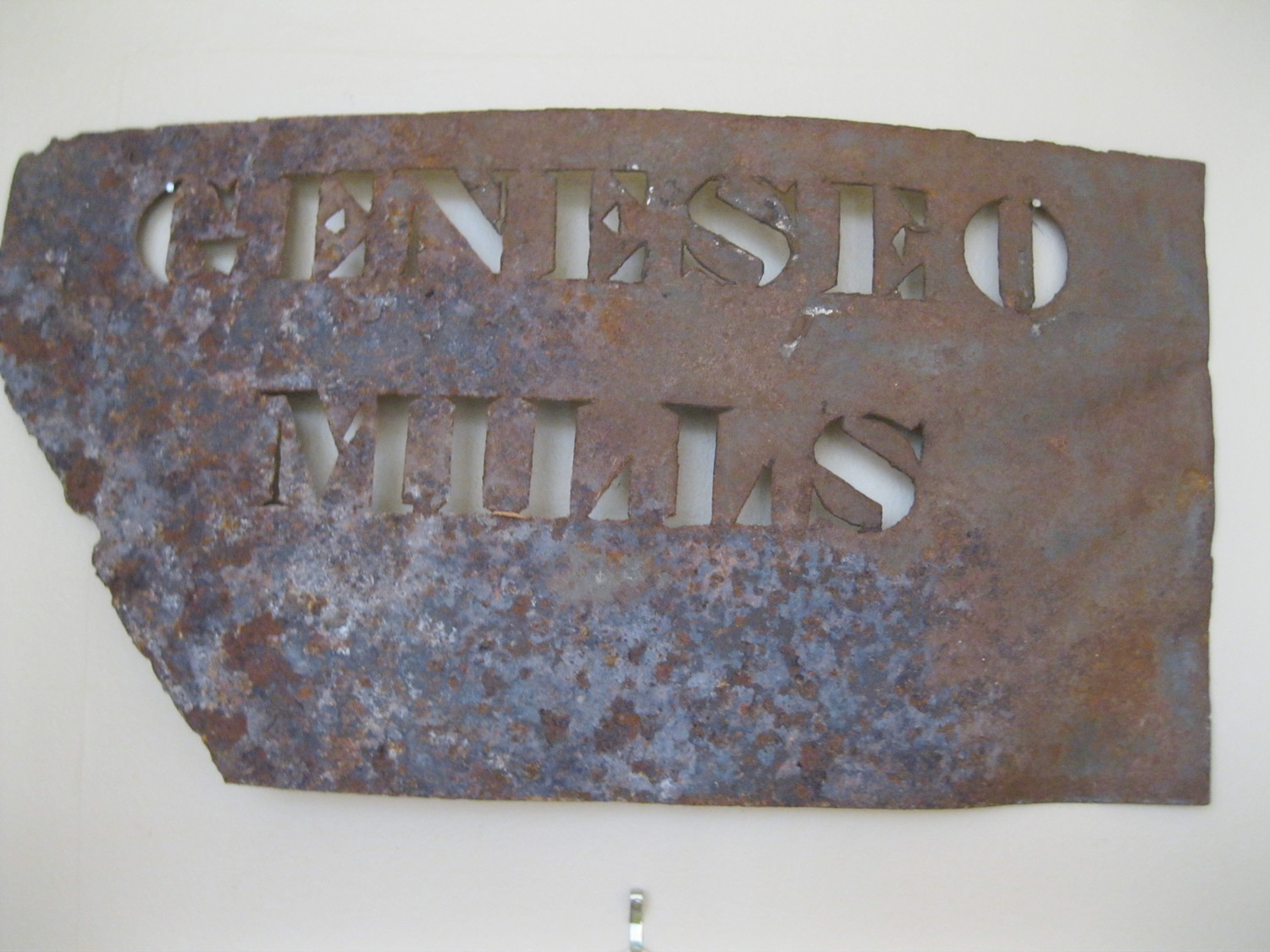 Glen Avon Mills Flour Bag- This white canvas bag was used to hold pastry flour ground at the Glen Avon gristmill. A gristmill was on the site as early as 1810, though the early one burned in 1878. Emme Light built the current building in 1879 and it still exists, repurposed as a home. This mill was best known for “Sweet Violet” and “Daisy” pastry flours, produced around 1950. Geneseo Mills Sign - Farmers brought grain to the mills where it was processed into flour, bagged, and shipped to markets in large cities in the eastern United States. In 1920 the Geneseo Mill, or Big Tree Mills, was destroyed by fire at a loss of $100,000 and much grain and flour. It was operated by Tomkinson, Kenyon, and Tomkinson Co. around this time.