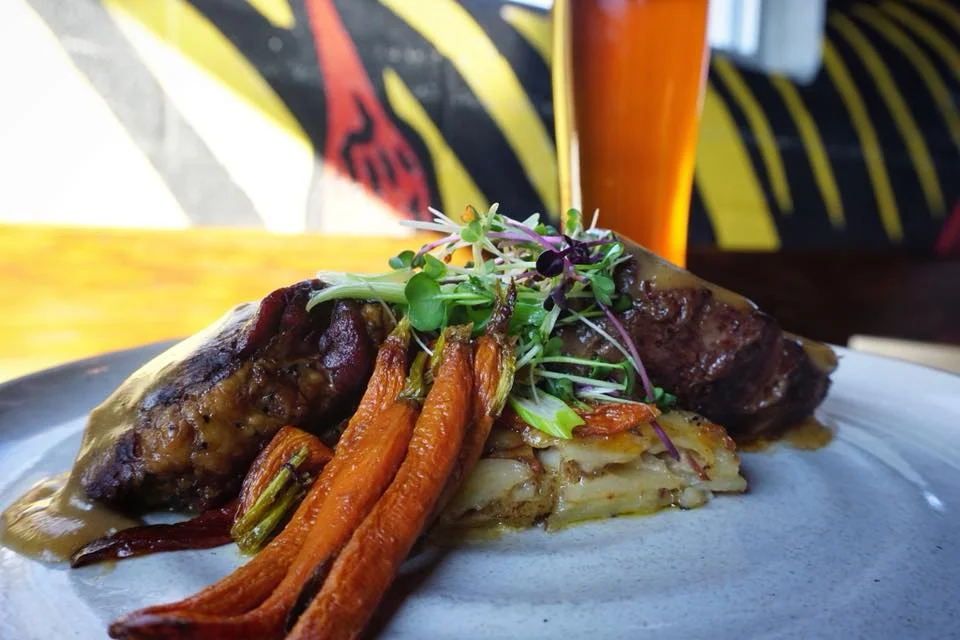 'Braised Short Rib'. Drizzled with bourbon gravy, our braised short rib sits on a bed of housemade scallop potatoes with roasted carrots.