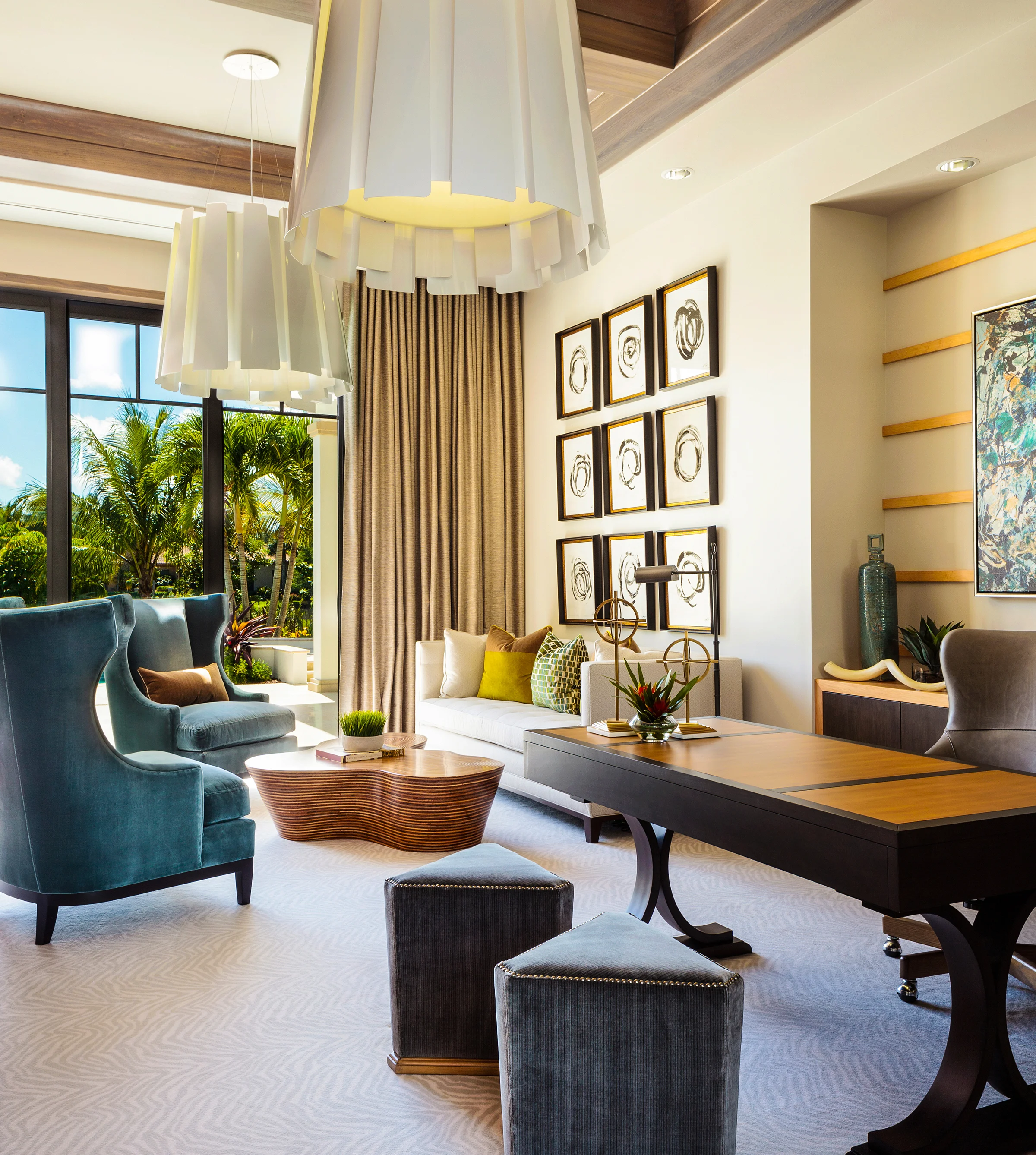 The beautiful play of relationships on grand scale chandeliers with curved furniture and coastal colors make for a luxurious study.