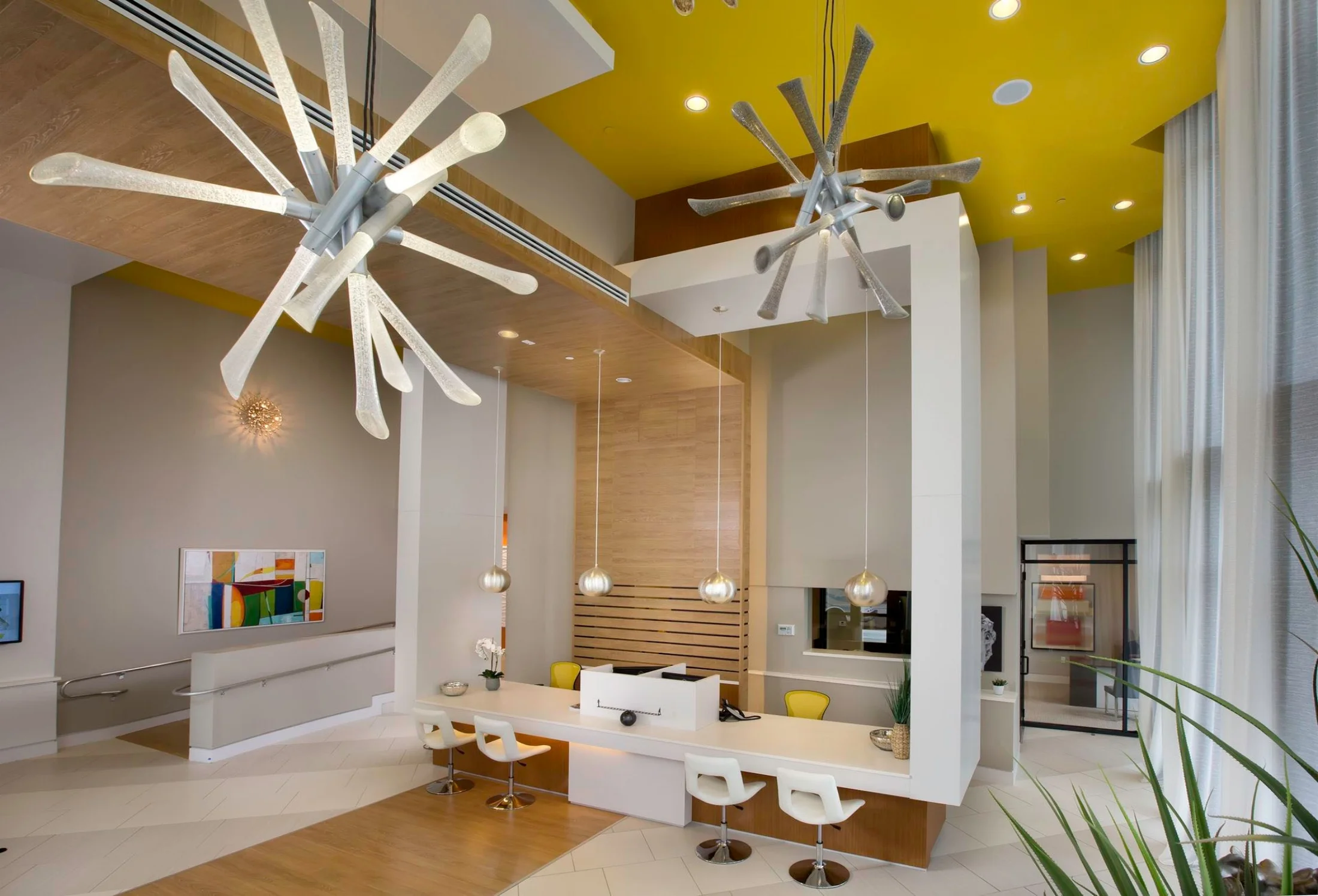 The over sized light fixtures and bold ceiling color create a wow factor in this modern clubhouse lobby.
