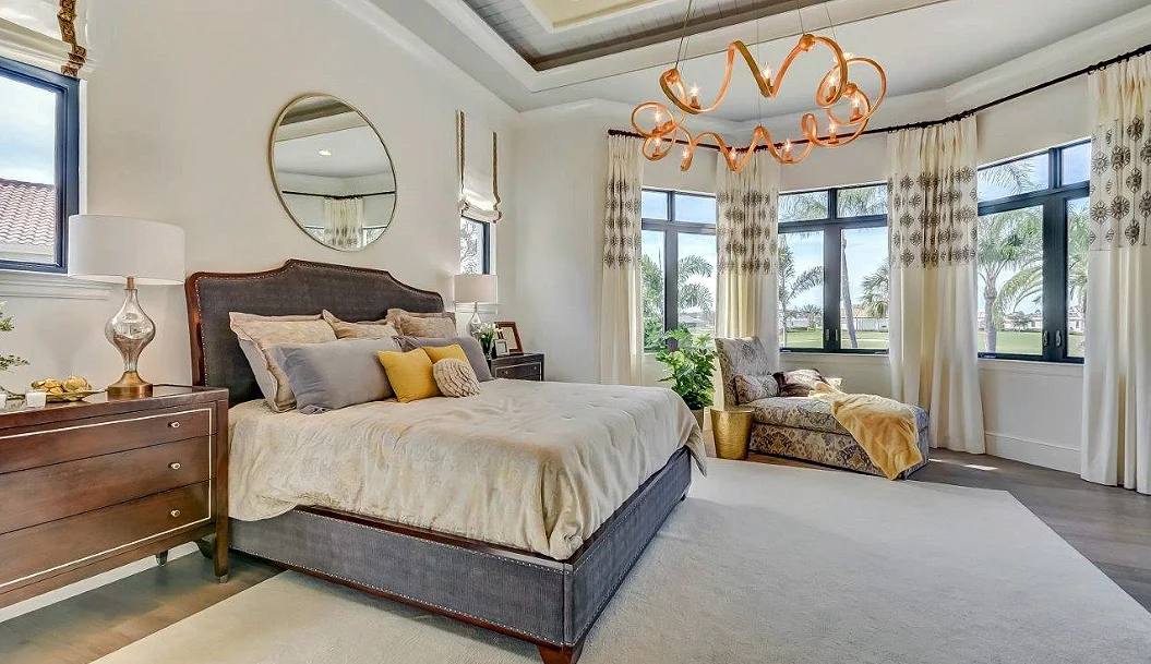 The bed features tufted upholstery on the headboard and foot board and sets an inviting tone for a room that has a softer color pallet.
