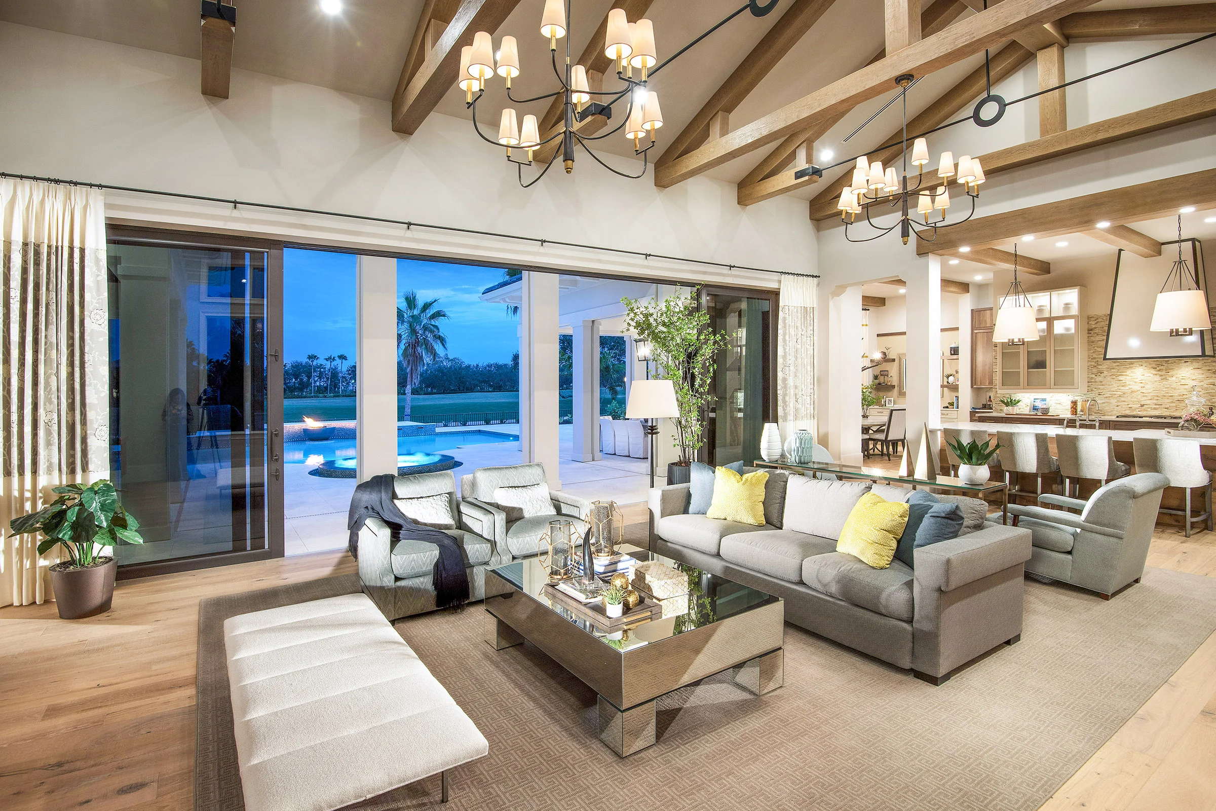 An earthy coastal design featuring tonal color background elements with a unique layer of colors in the accessories. The bleached hardwood flooring and wood beam ceiling detail brings warmth to the space.