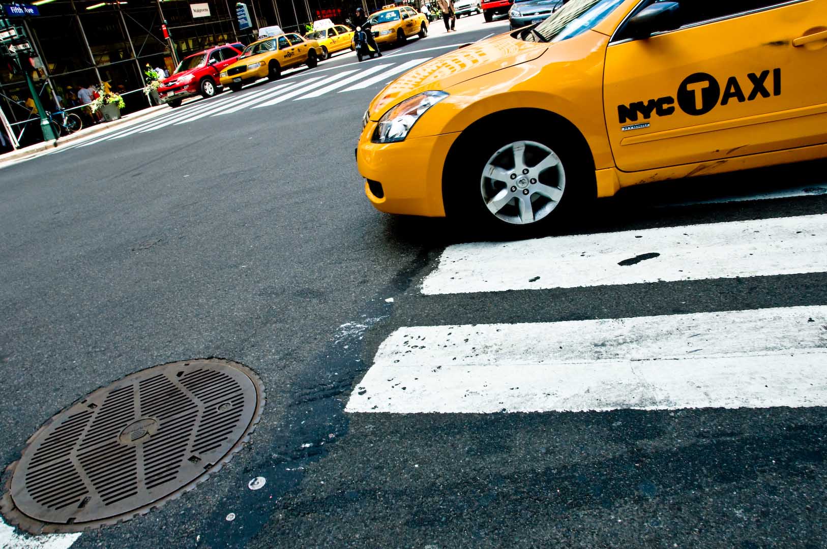 Down the drain yellow cab nyc taxi new york city manhattan car sidewalk cross road stop downtown.jpg
