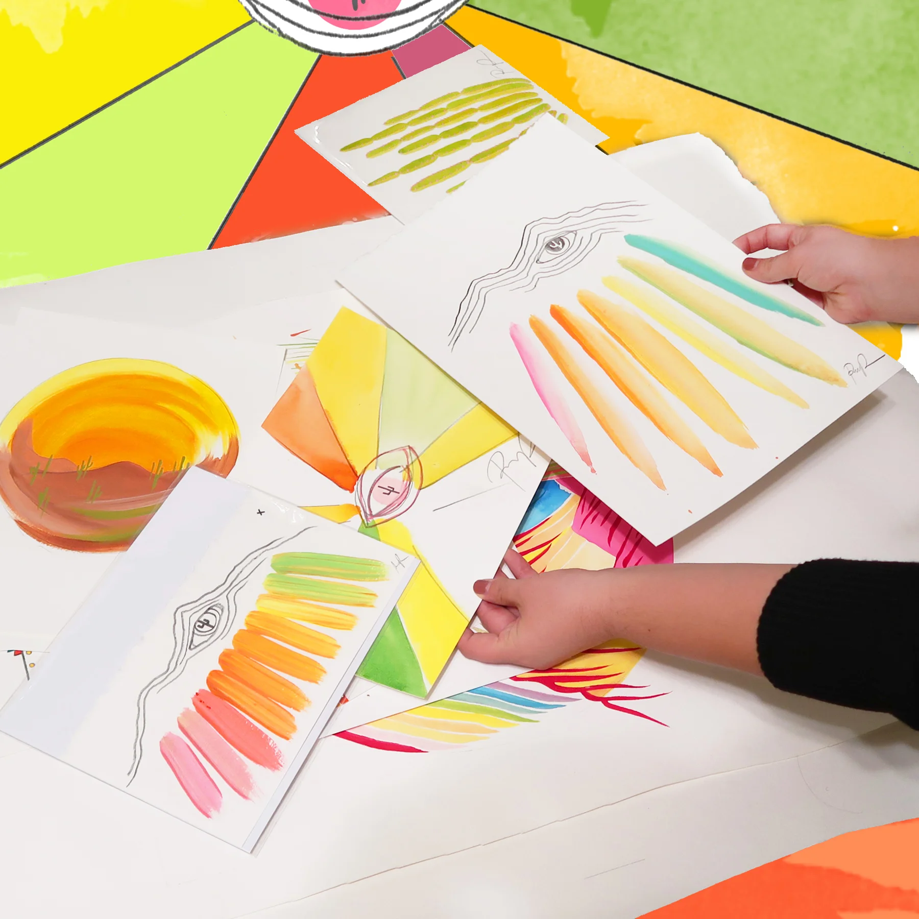 holding rainbow paintings.jpg