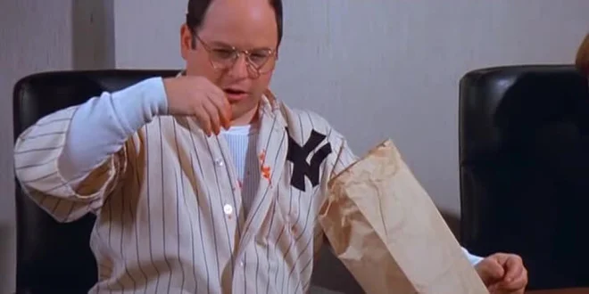 George intentionally dribbles strawberries down the front of Babe Ruth's jersey