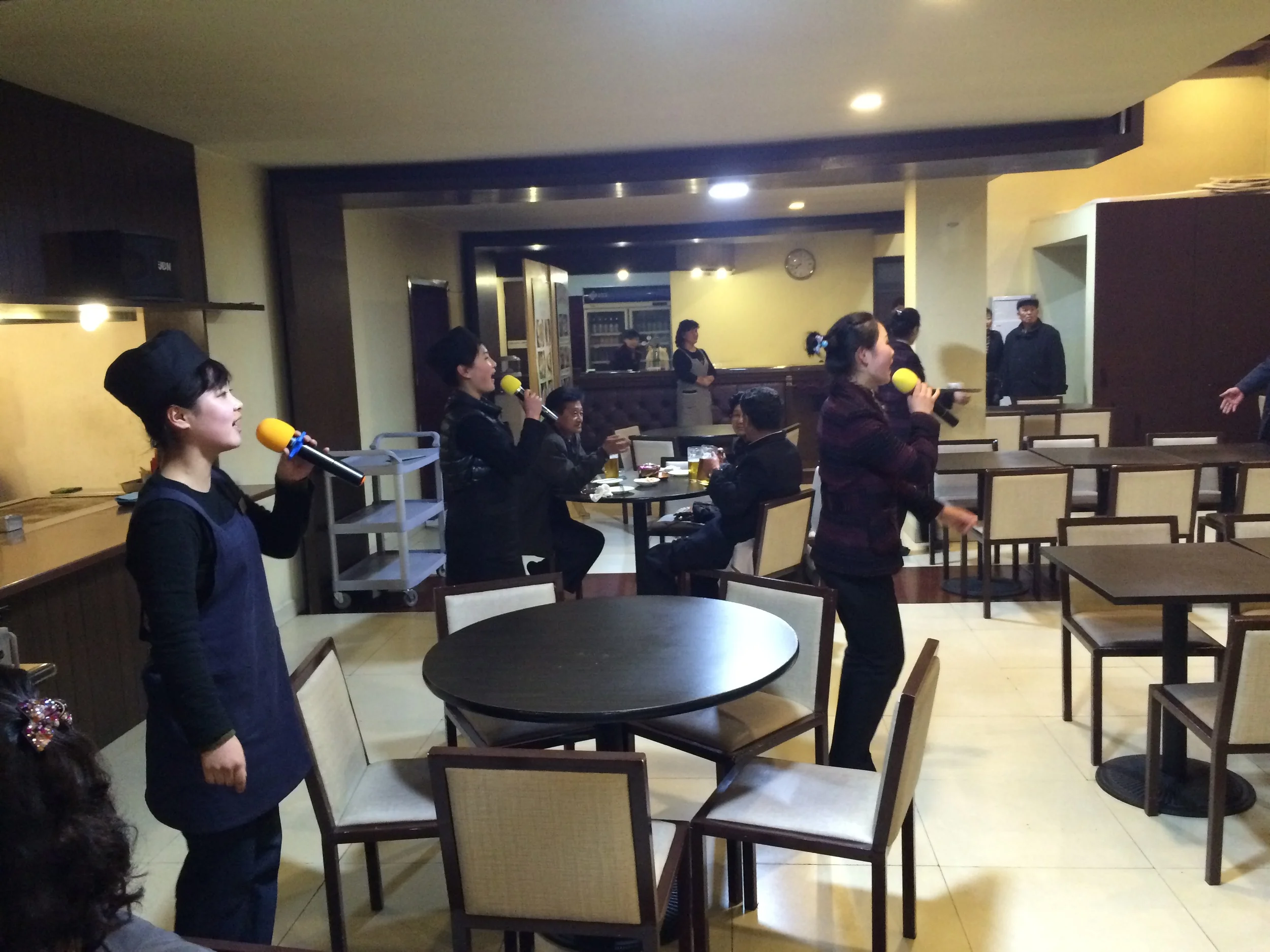 This restaurant in Pyongyang is innovating - they get the waitresses and cooks to sing in the evening! 