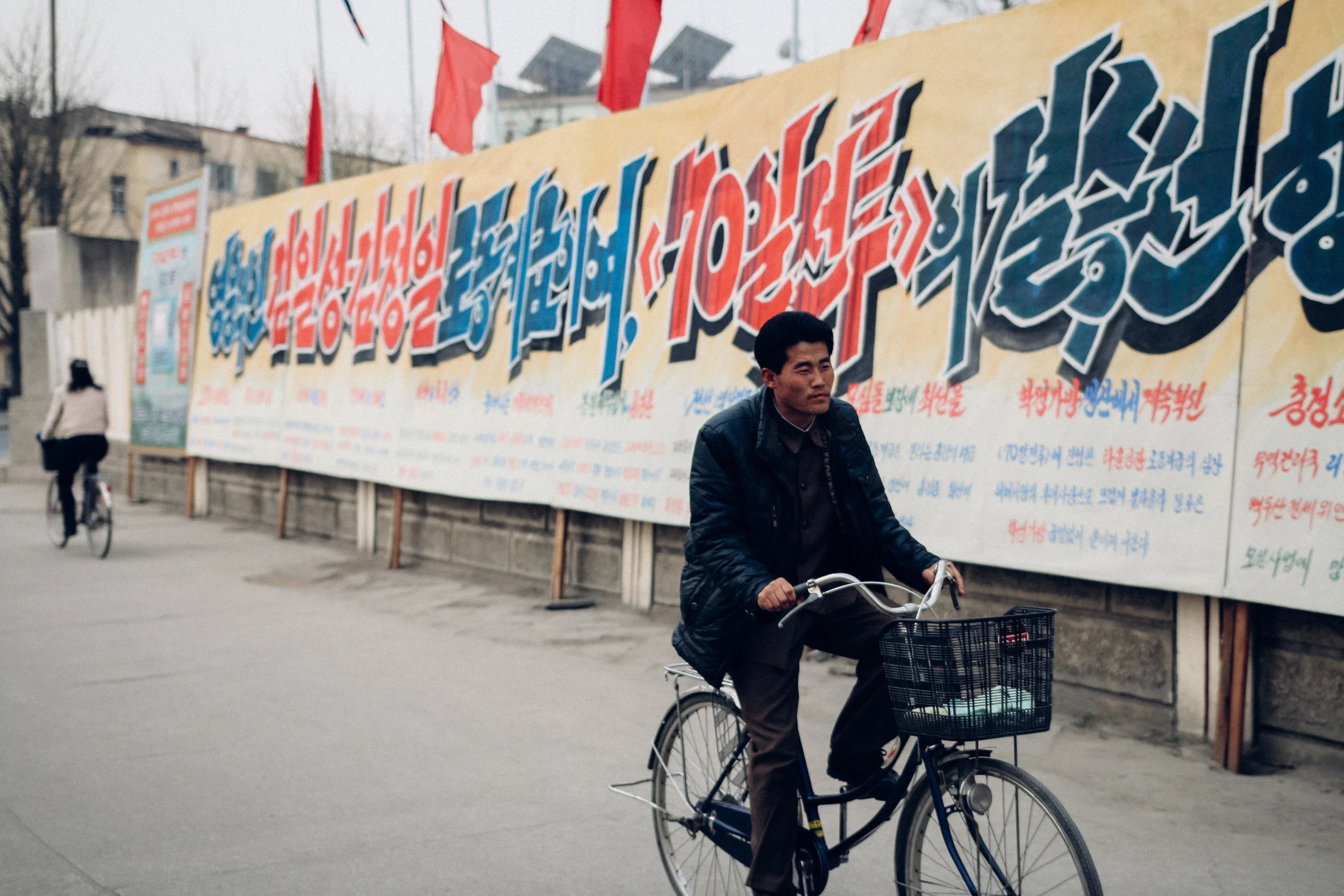Man cycles past 70 day speed battle slogans. April, 2016 (Photo by Joe Han)