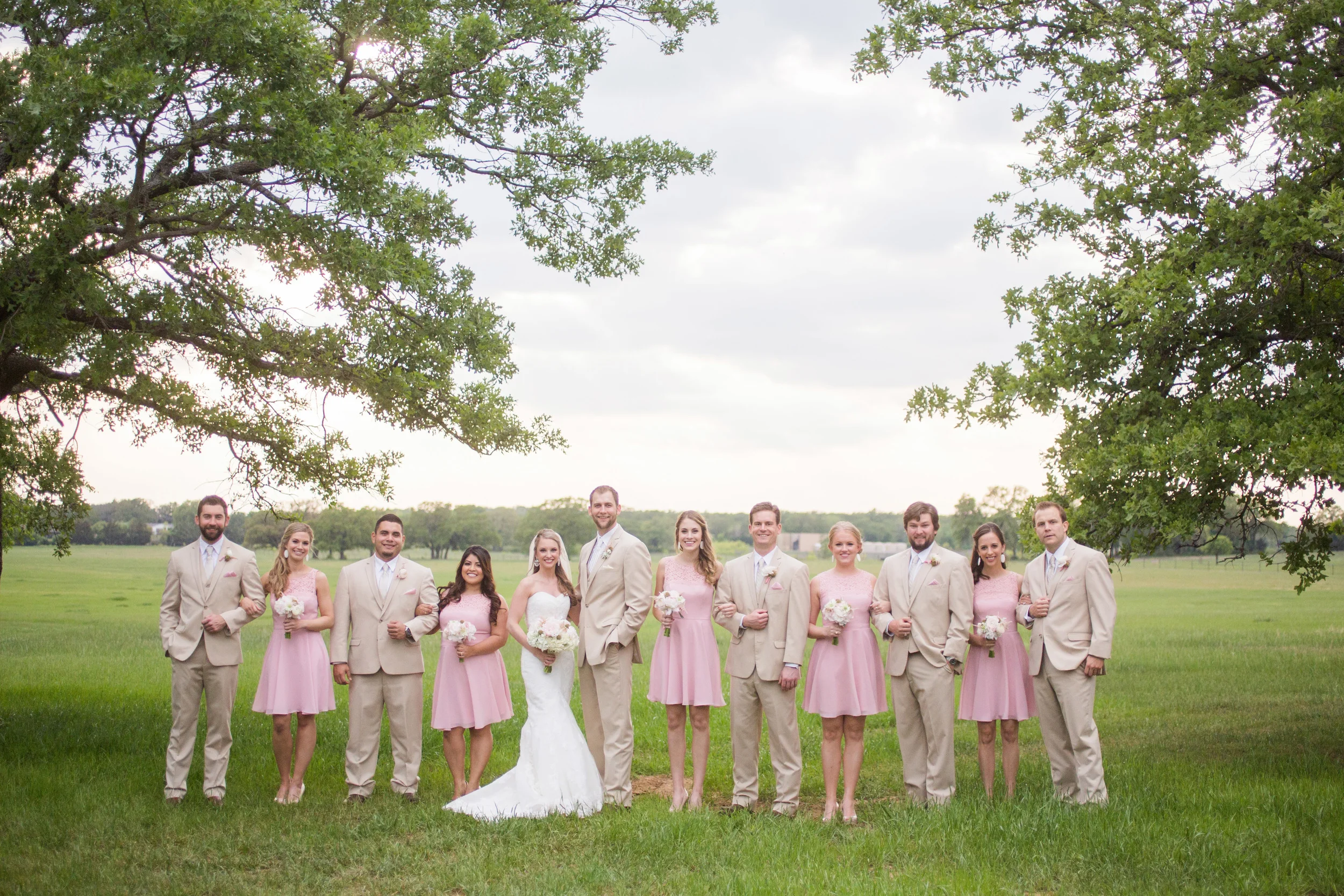 Bridal party pink bridesmaid dresses and khaki suits