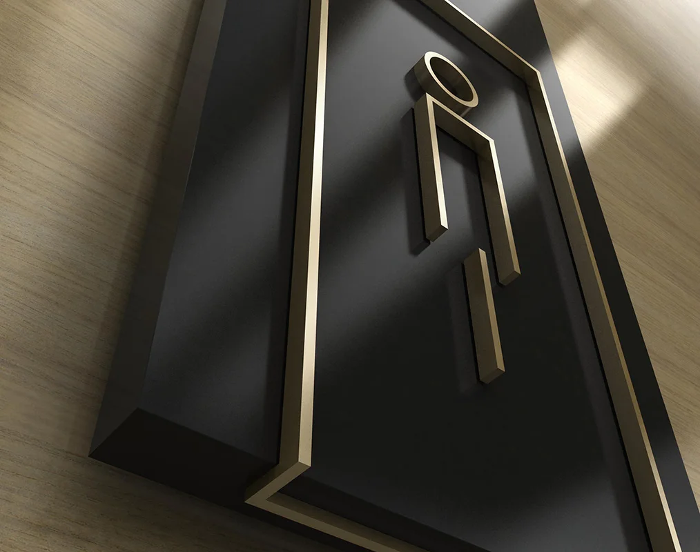 Detail view of an amenity sign in painted acrylic and brushed brass.