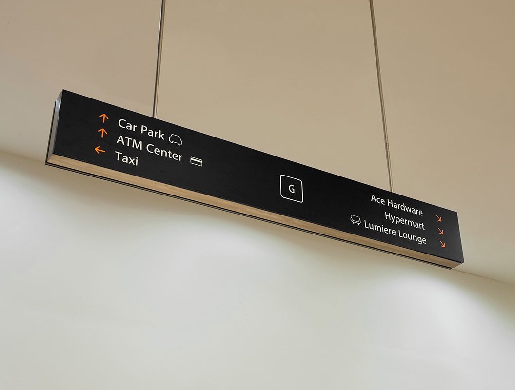 Overhead directional signage in stainless steel and back lit, matte black acrylic.