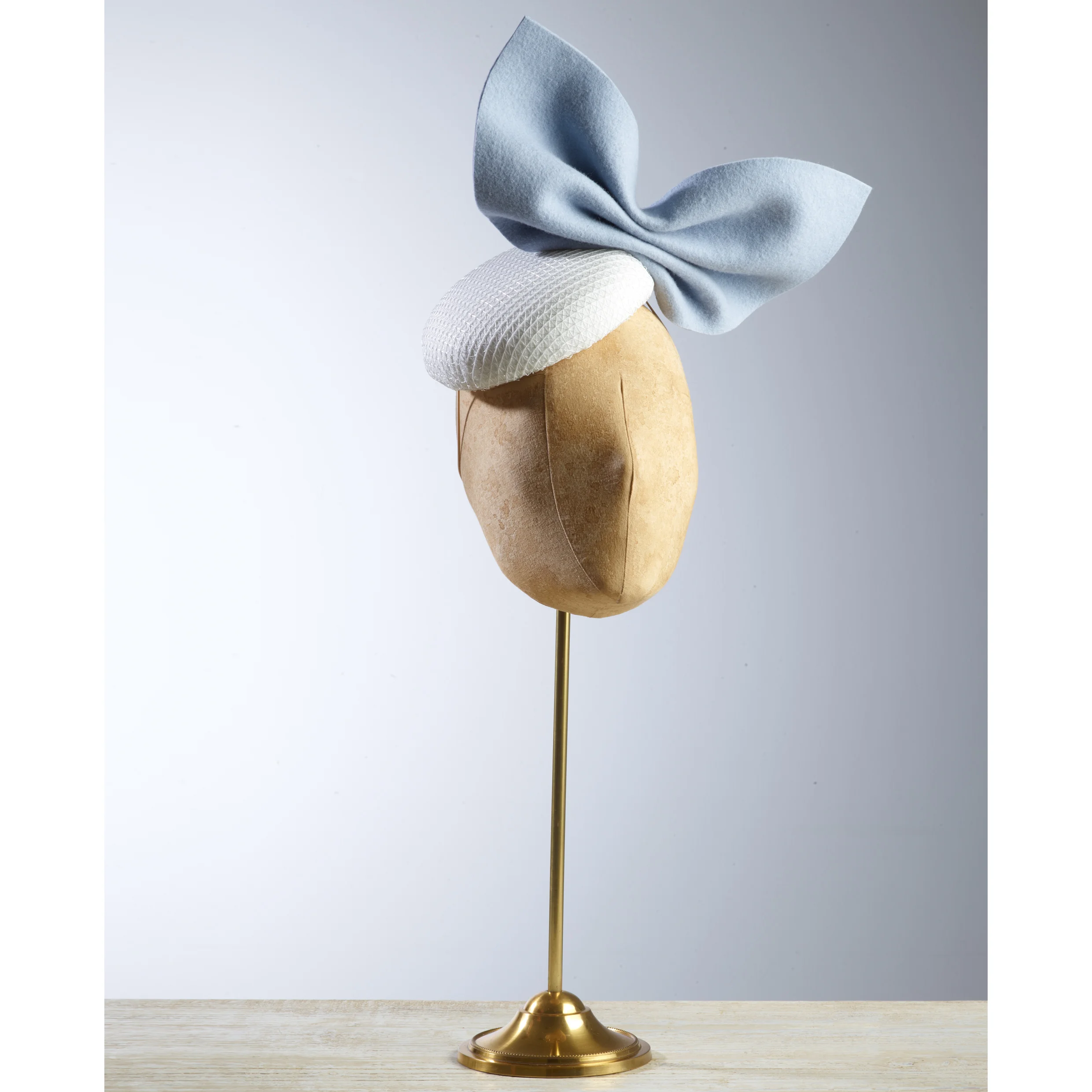 PLISSE - £75 White button headpiece with pale blue wool felt bow.
