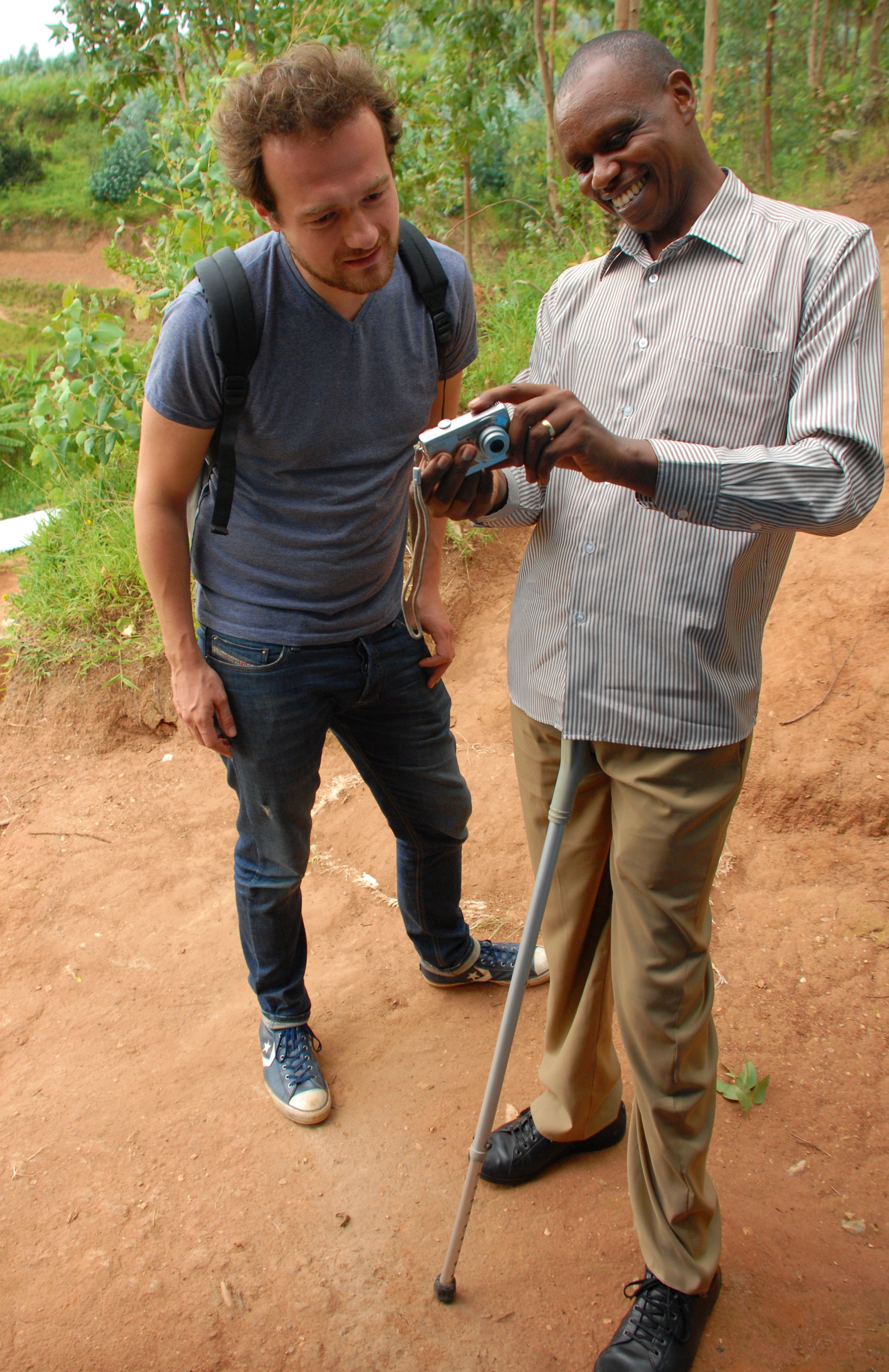  Evariste showing Lennart some pictures of smallholder farmers who received health insurance from the 2014 harvest. 