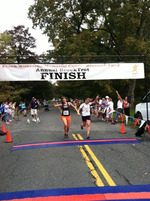 Caroline crossing the finish line with big sis Lizzie