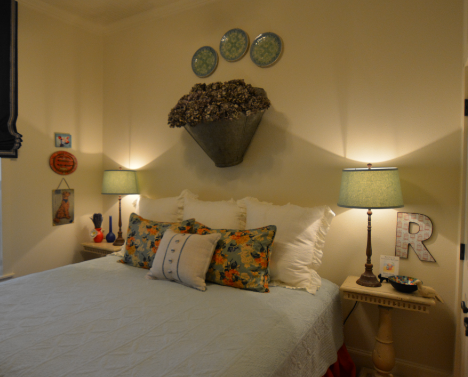 Antique plates above a bed. 