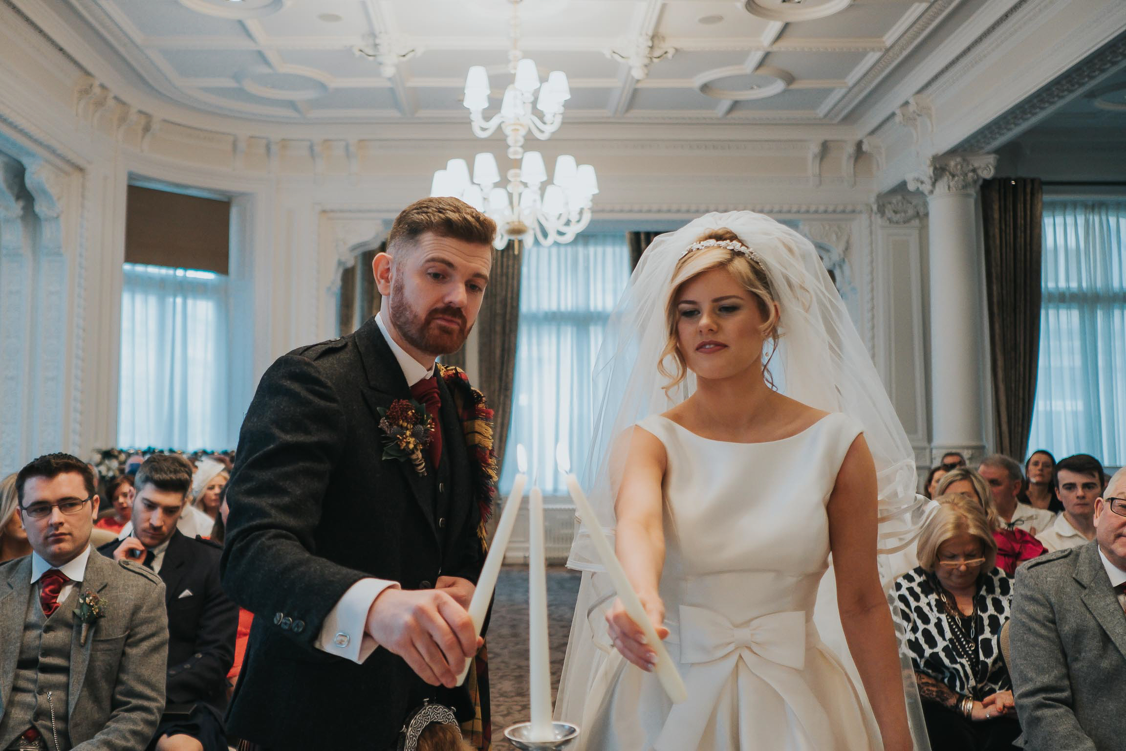 the bride and groom lighting the Unity Candle  during their wedding ceremony in Liverpool