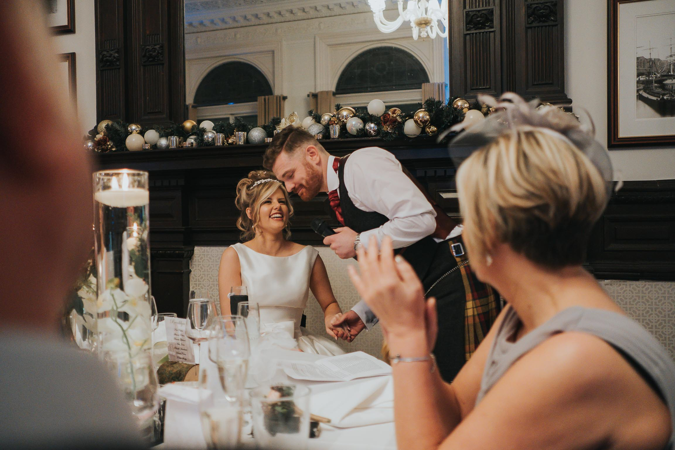 bride having a quite word with the groom during his speech