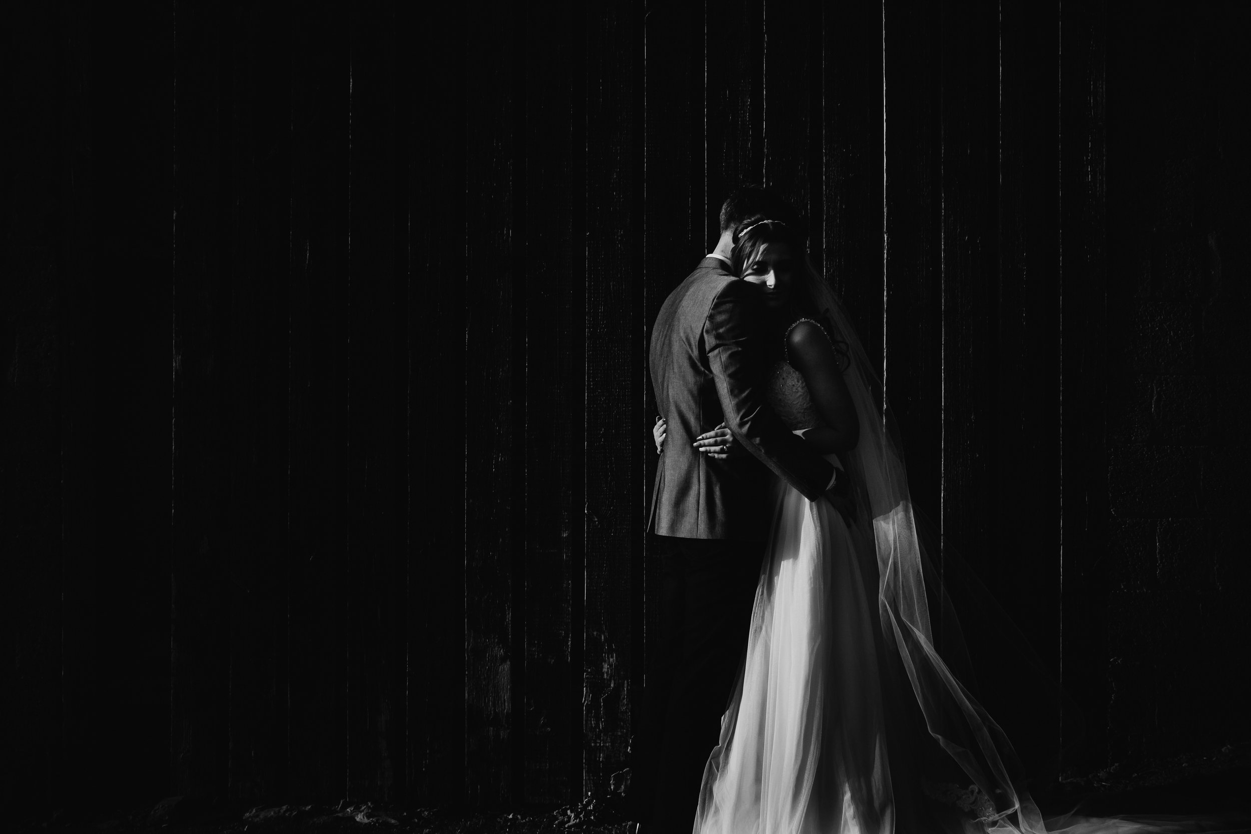 black and white image of a bride and groom hugging after becoming man and wife