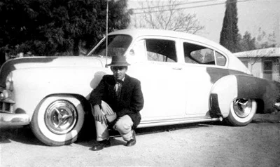 1957 ^ Manuel Ruben Delgado with his '49 Chevy, "El Chuco"