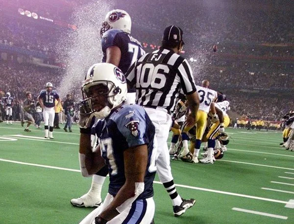 January 30, 2000 ^ Disappointed Titans wide receiver Kevin Dyson (87) in the foreground......Field Judge Al Jury (106) finishes up his Super Bowl duties......Rams linebacker Mike Jones (35) celebrates with his teammates