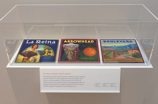 VINTAGE ORANGE CRATE LABELS Fascinated by the graphic design of orange crate labels in the late nineteenth and early twentieth centuries, Sakoguchi has used their detailed, small format as a creative template. The labels' romanticized vision of the California landscape has provided a playful visual language with which he addresses serious themes. The orange crate label format is also a nod to his father, a Japanese immigrant who owned a grocery store.