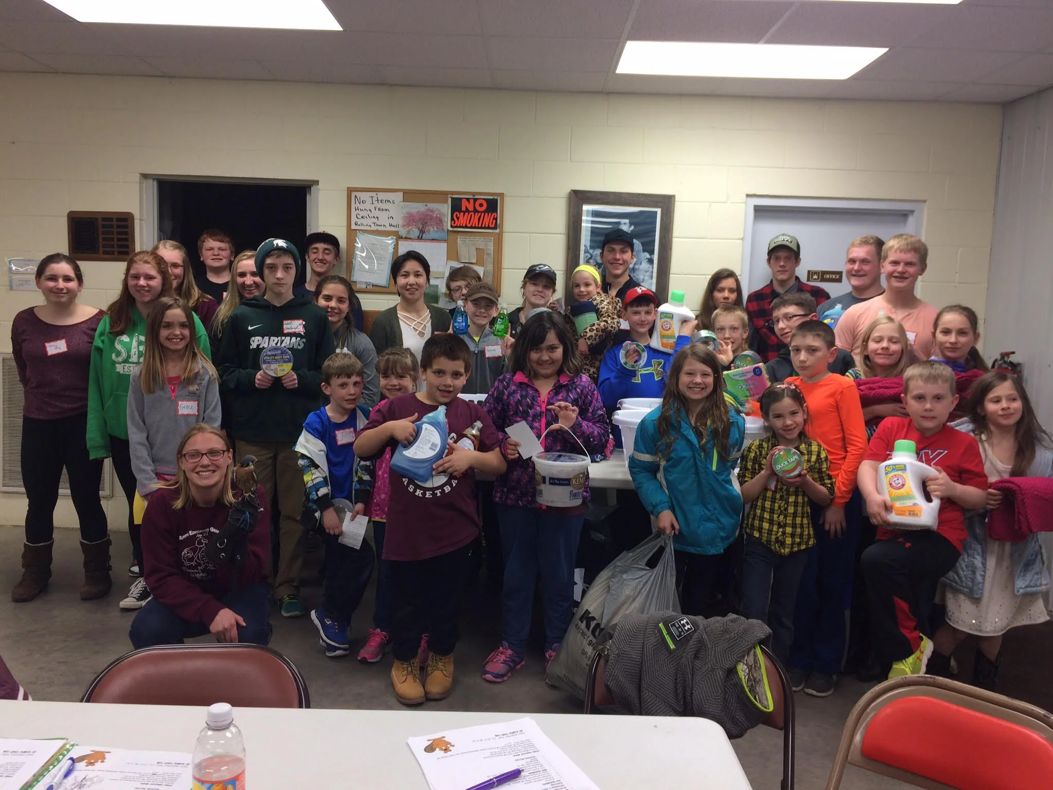 The Antigo 4-H donated supplies to REGI at one of their April 2017 meetings. The group poses with Director of Education, Elise, and Benji the American Kestrel. 