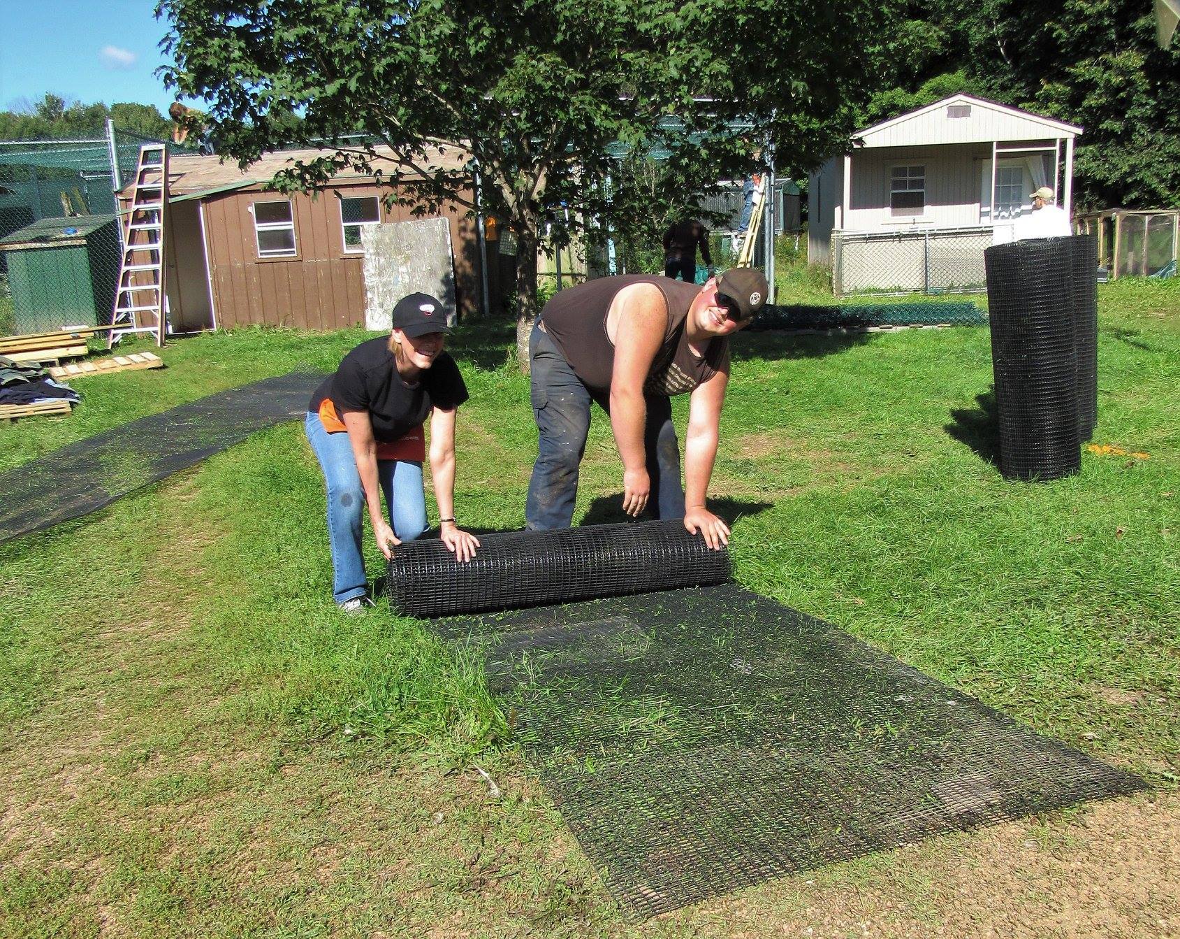 Rolling up the old fencing so we can use it again. As a non profit we are frugal. Hunter Petroskey and Margaret Getzin