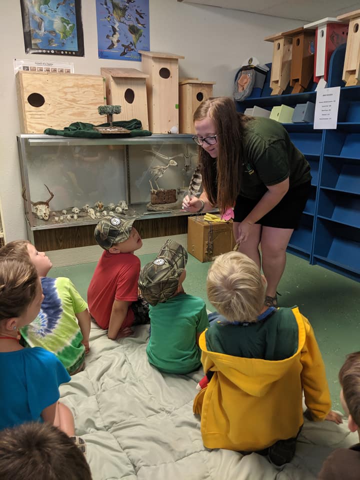 Intern Bailee teaching kids the amazing feather adaptations of owls