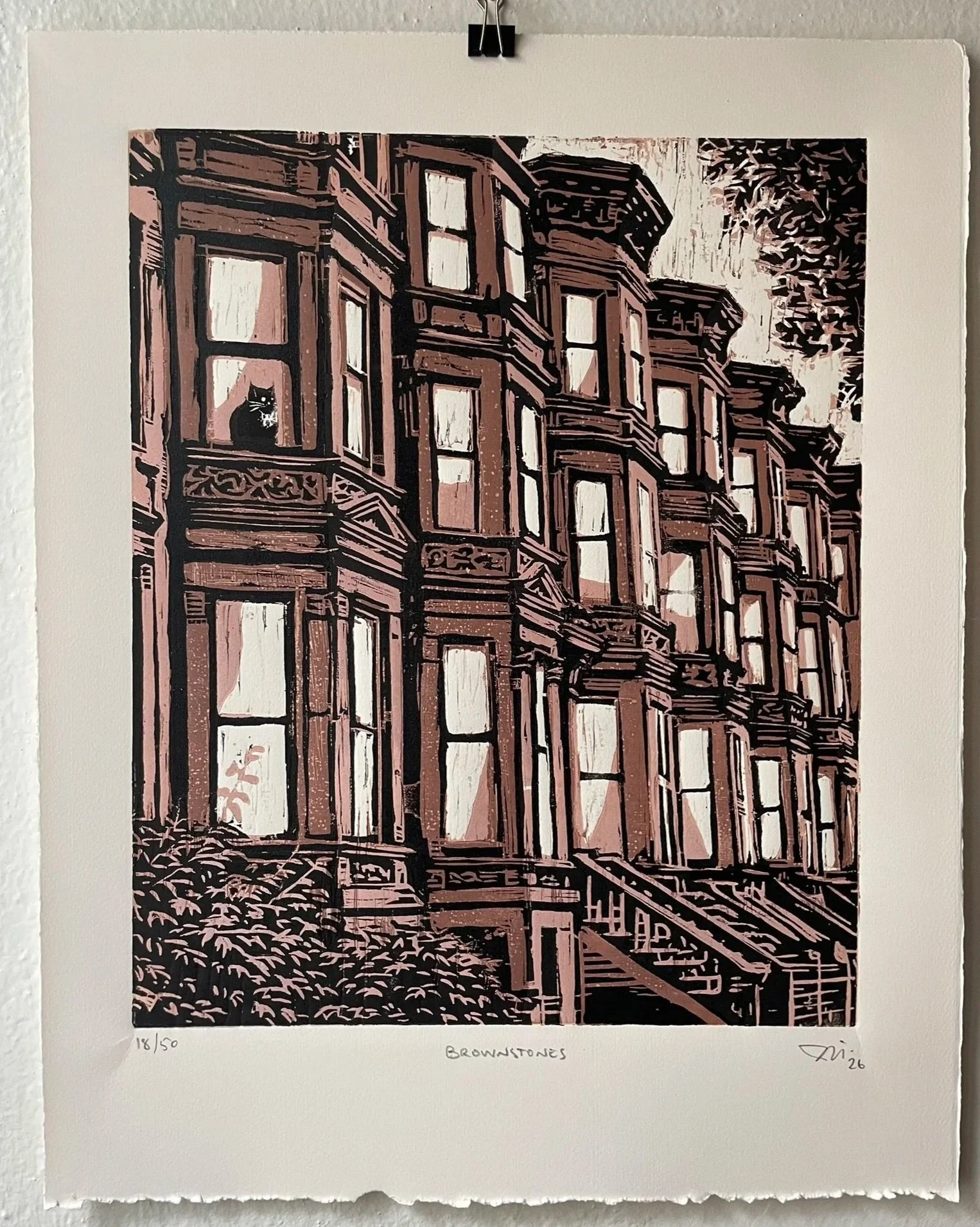 A woodblock print of NYC's iconic Brownstone row houses with a cat sitting in the window