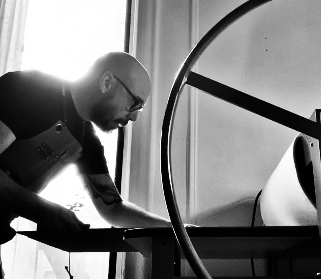 NYC artist Benjamin Lindsay prepares to run a woodblock print through his print press