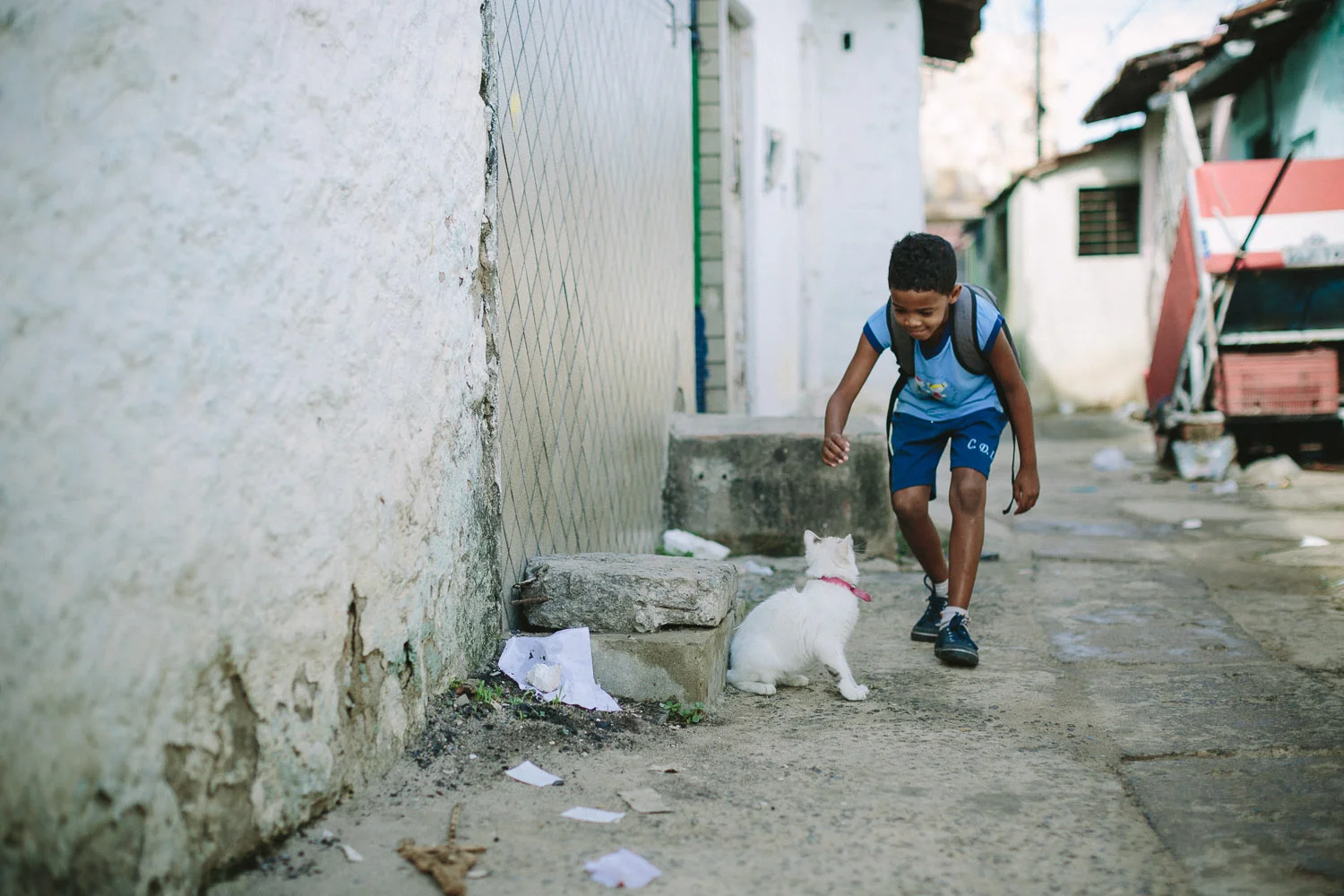 Emidio is very playful and on the way to school he spots a cat and takes the time to play with it. Emidio walking to his classes at the Compassion Center.