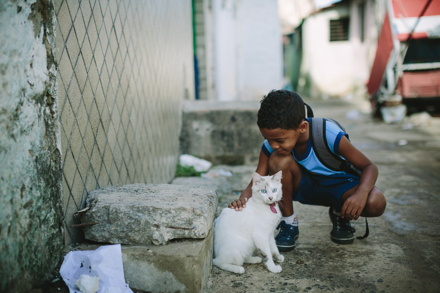   Emidio is very playful and on the way to school he spots a cat and takes the time to play with it. Emidio walking to his classes at the Compassion Center.  