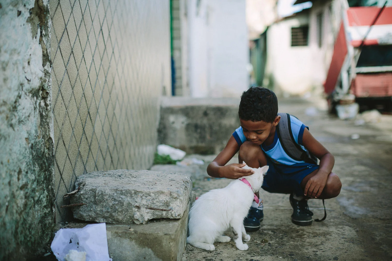 Emidio is very playful and on the way to school he spots a cat and takes the time to play with it. Emidio walking to his classes at the Compassion Center.